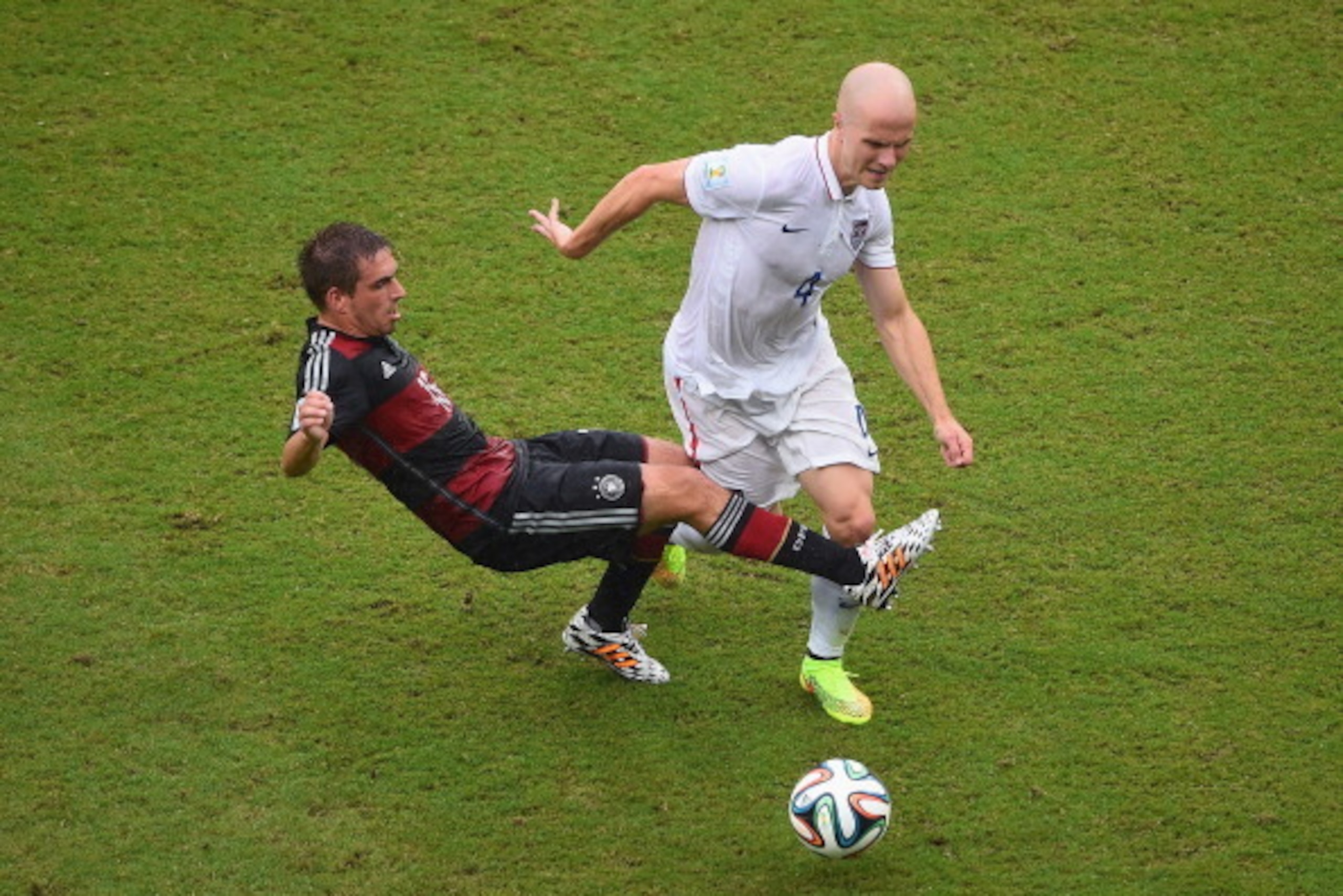 RECIFE, BRAZIL - JUNE 26:  Philipp Lahm of Germany challenges Michael Bradley of the United States during the 2014 FIFA World Cup Brazil group G match between the United States and Germany at Arena Pernambuco on June 26, 2014 in Recife, Brazil.  (Photo by