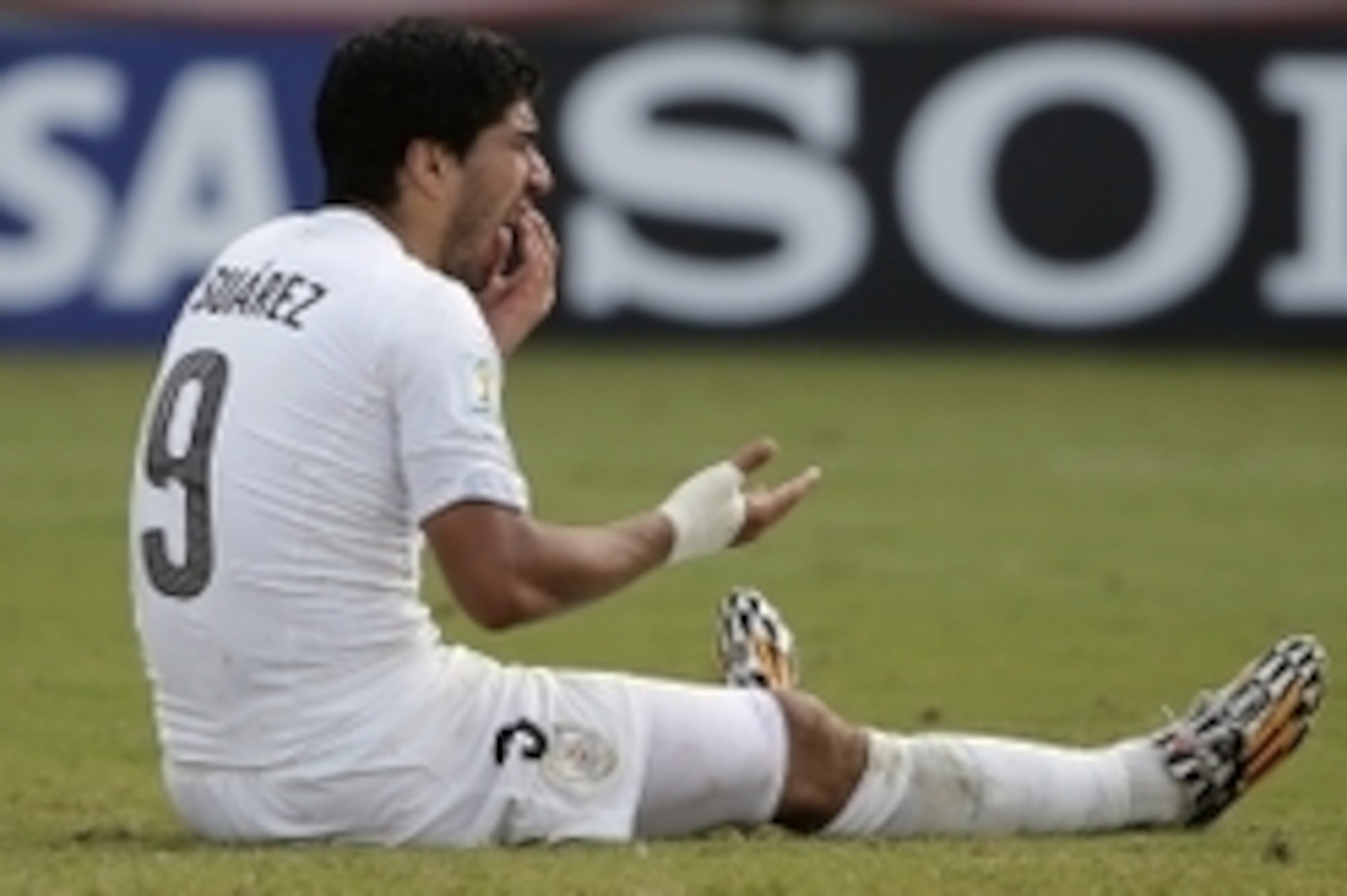 Jun 24, 2014; Natal, Rio Grande do Norte, BRAZIL; Uruguay forward Luis Suarez (9) sits on the ground checking his mouth after he allegedly bit Italy defender Giorgio Chiellini (3) during the second half of Uruguay's 1-0 win over Italy in a 2014 World Cup 