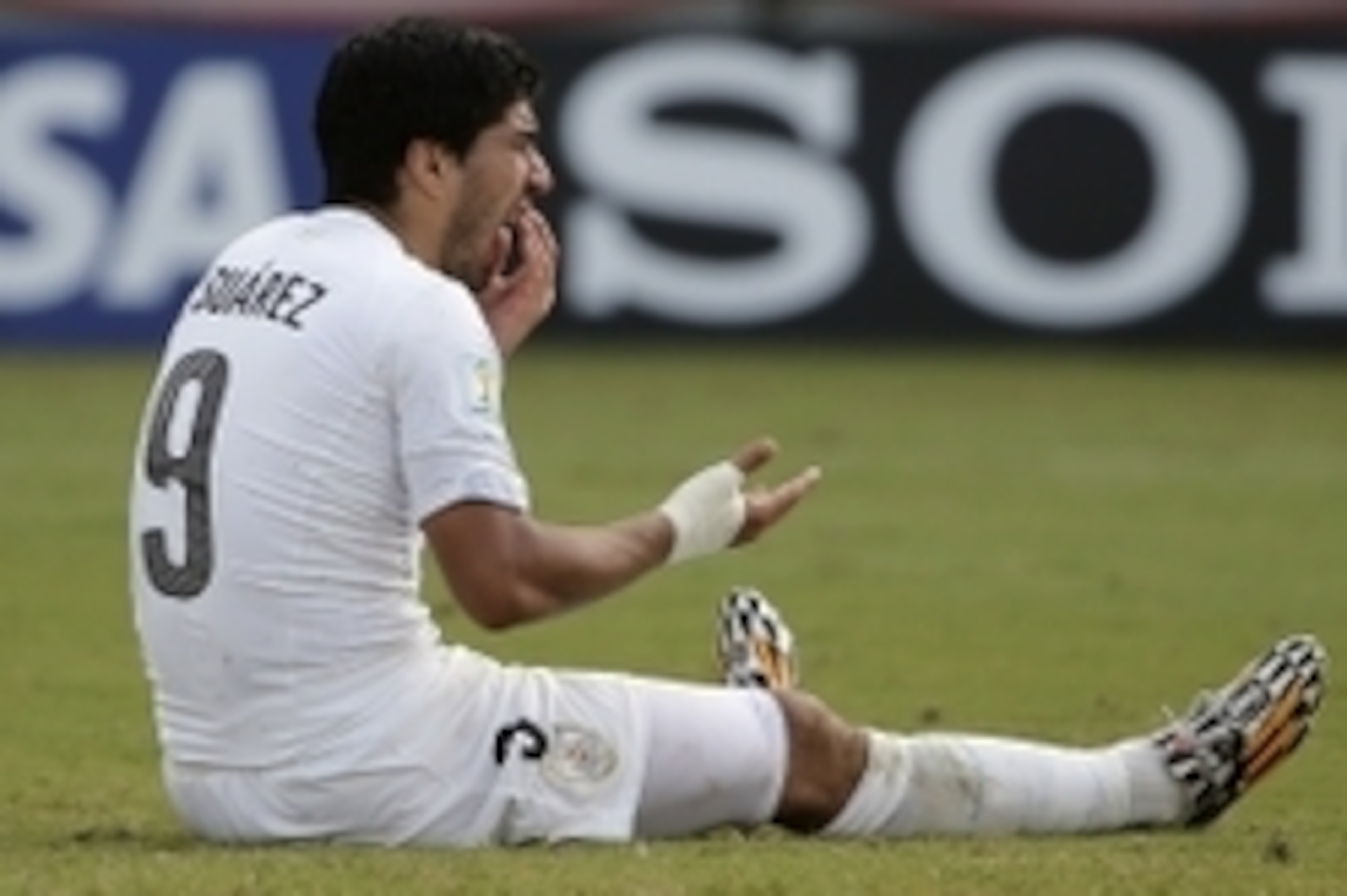 Jun 24, 2014; Natal, Rio Grande do Norte, BRAZIL; Uruguay forward Luis Suarez (9) sits on the ground checking his mouth after he allegedly bit Italy defender Giorgio Chiellini (3) during the second half of Uruguay's 1-0 win over Italy in a 2014 World Cup 
