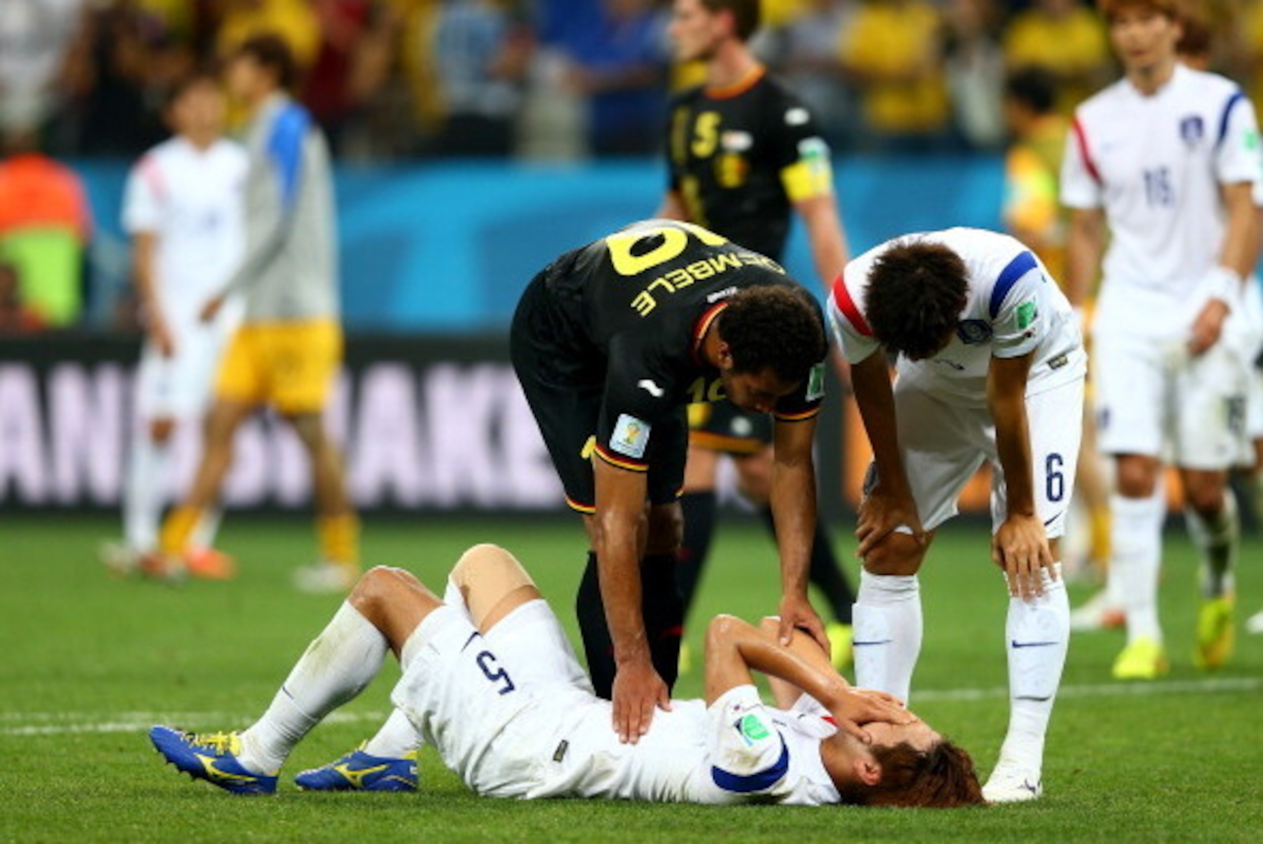 SAO PAULO, BRAZIL - JUNE 26:  Moussa Dembele of Belgium and Hwang Seok-Ho of South Korea console Kim Young-Gwon after the 2014 FIFA World Cup Brazil Group H match between South Korea and Belgium at Arena de Sao Paulo on June 26, 2014 in Sao Paulo, Brazil.