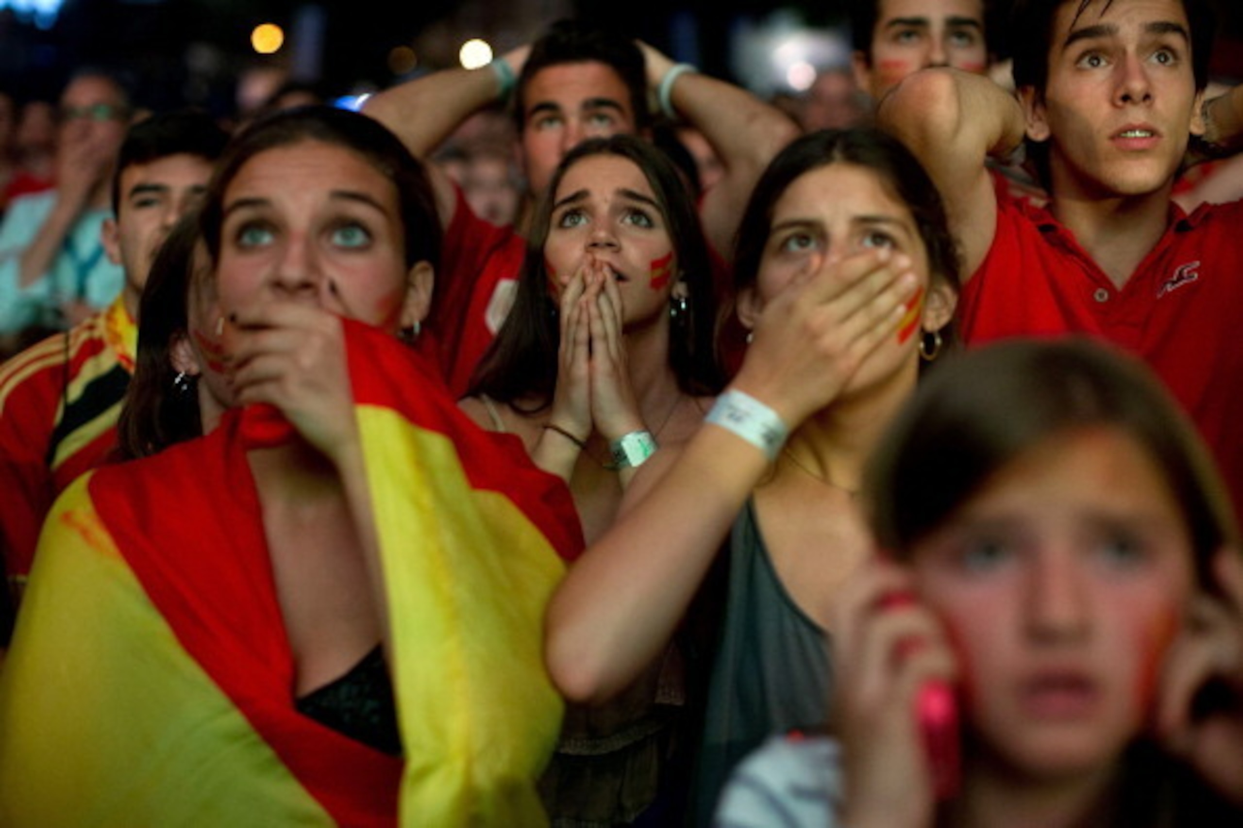 MADRID, SPAIN - JUNE 18:  Spanish fans react while watching their team play against the Chileans on the giant screen showing the FIFA World Cup match between Spain and Chile on June 18, 2014 in Madrid, Spain. Spain, current football World Cup champion, as