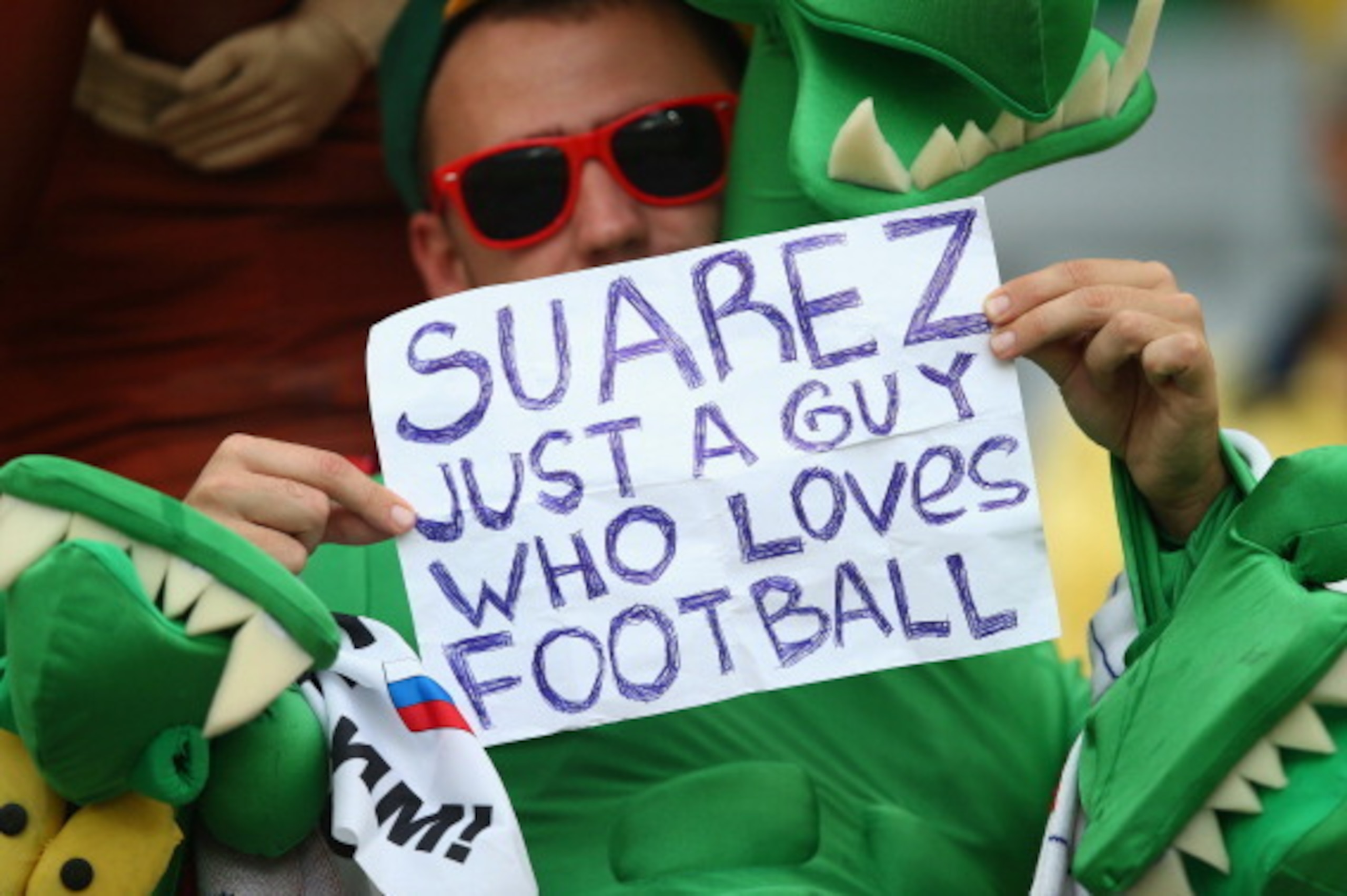 CURITIBA, BRAZIL - JUNE 26: A fan holds up a sign reading 'Suarez Just A Guy Who Loves Football' prior to the 2014 FIFA World Cup Brazil Group H match between Algeria and Russia at Arena da Baixada on June 26, 2014 in Curitiba, Brazil.  (Photo by Clive Ro