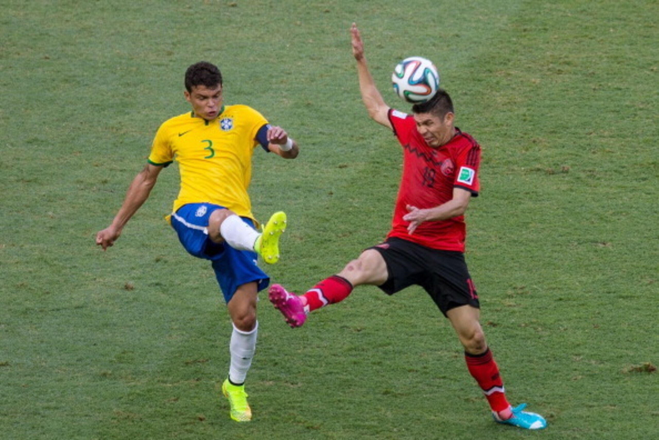 FORTALEZA, BRAZIL - JUNE 17: Thiago Silva of Brazil and Oribe Peralta of Mexico battle for the ball during the 2014 FIFA World Cup Brazil Group A match between Brazil and Mexico at Castelao on June 17, 2014 in Fortaleza, Brazil. (Photo by Miguel Tovar/G FORTALEZA, BRAZIL - JUNE 17: Thiago Silva of Brazil and Oribe Peralta of Mexico battle for the ball during the 2014 FIFA World Cup Brazil Group A match between Brazil and Mexico at Castelao on June 17, 2014 in Fortaleza, Brazil. (Photo by Miguel Tovar/G