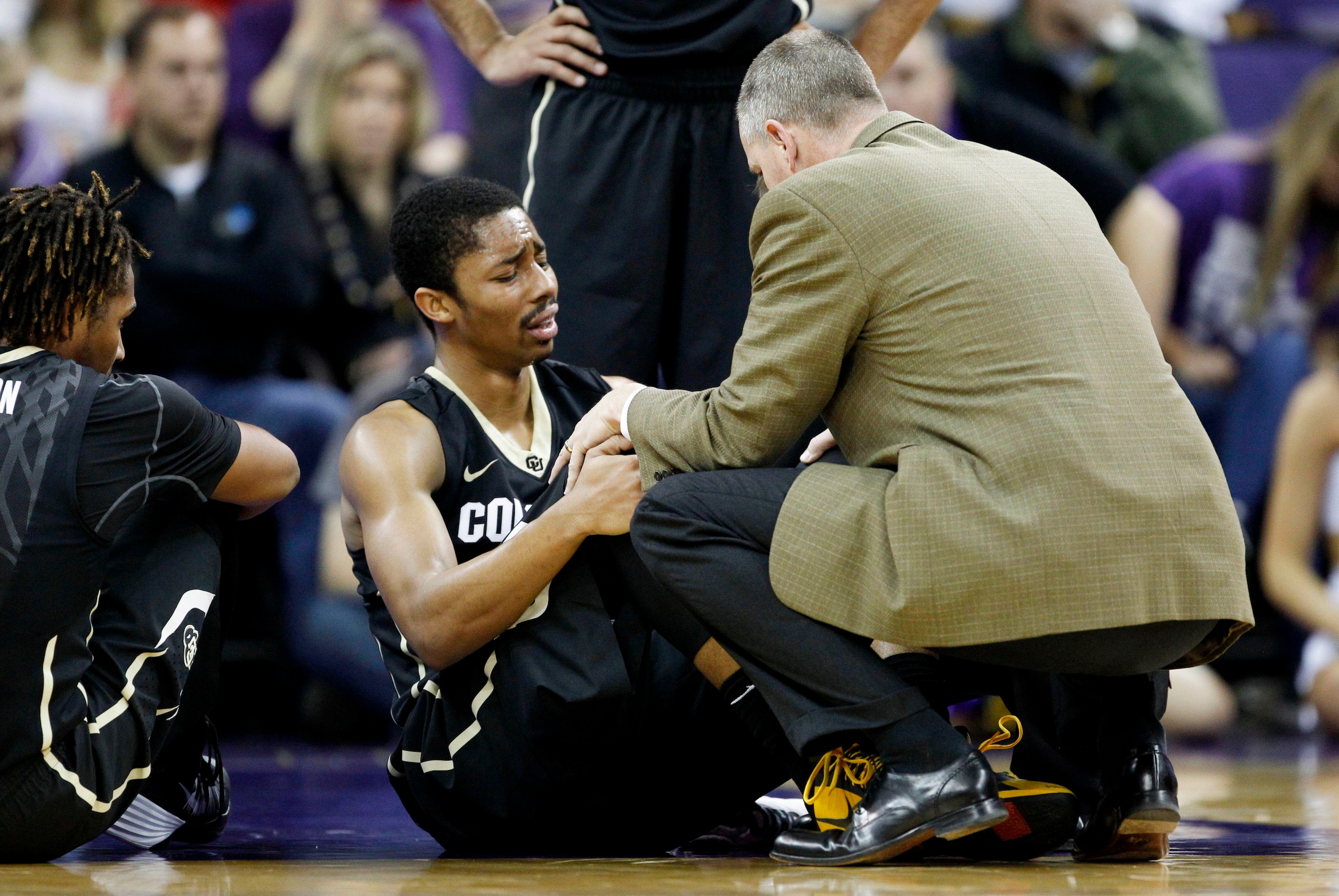 Jan 12, 2014; Seattle, WA, USA; Colorado Buffaloes guard Spencer Dinwiddie (25) is consoled by head coach Tad Boyle after suffering an injury during the first half against the Washington Huskies at Alaska Airlines Arena at Hec Edmundson Pavilion. Mandator