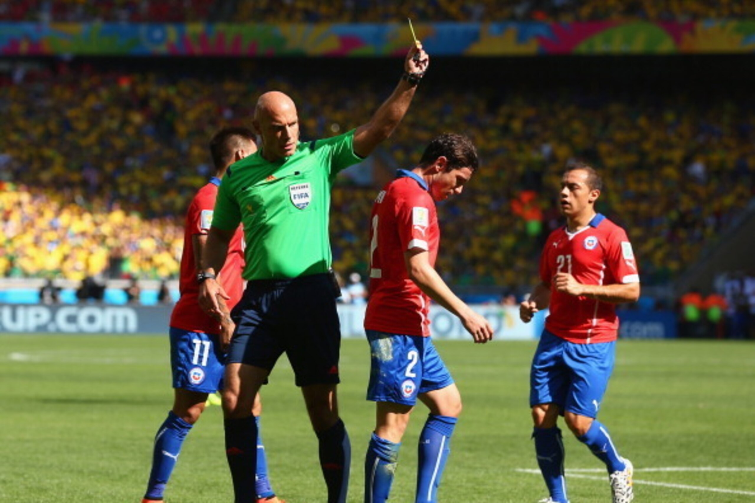 BELO HORIZONTE, BRAZIL - JUNE 28: Eugenio Mena of Chile is shown a yellow card by referee Howard Webb during the 2014 FIFA World Cup Brazil round of 16 match between Brazil and Chile at Estadio Mineirao on June 28, 2014 in Belo Horizonte, Brazil.  (Photo 