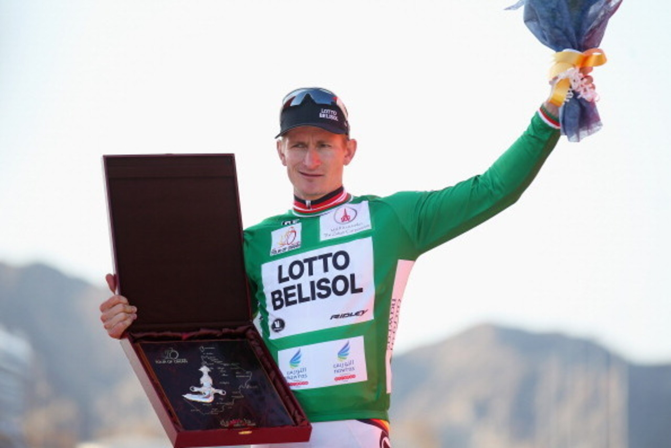 MATRAH CORNICHE, OMAN - FEBRUARY 23:  Andre Greipel of Germany and Lotto-Belisol pulls on the green jersey after winning the points competition overall and also stage six of the 2014 Tour of Oman, a 146km stage from As Sifah to the Matrah Corniche on Febr