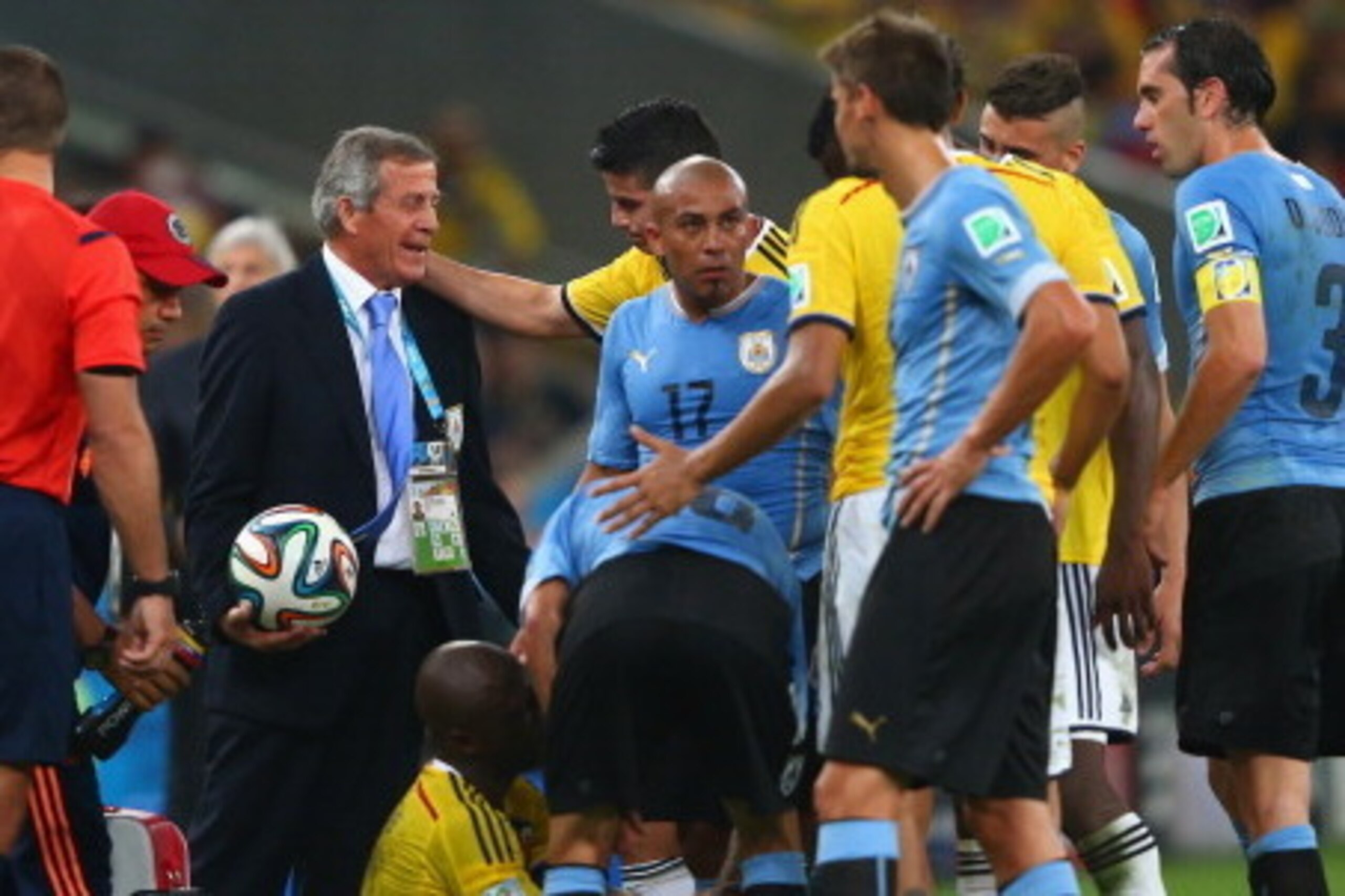 RIO DE JANEIRO, BRAZIL - JUNE 28: Head coach Oscar Tabarez of Uruguay looks on as Pablo Armero of Colombia sits on the field after a challenge during the 2014 FIFA World Cup Brazil round of 16 match between Colombia and Uruguay at Maracana on June 28, 201