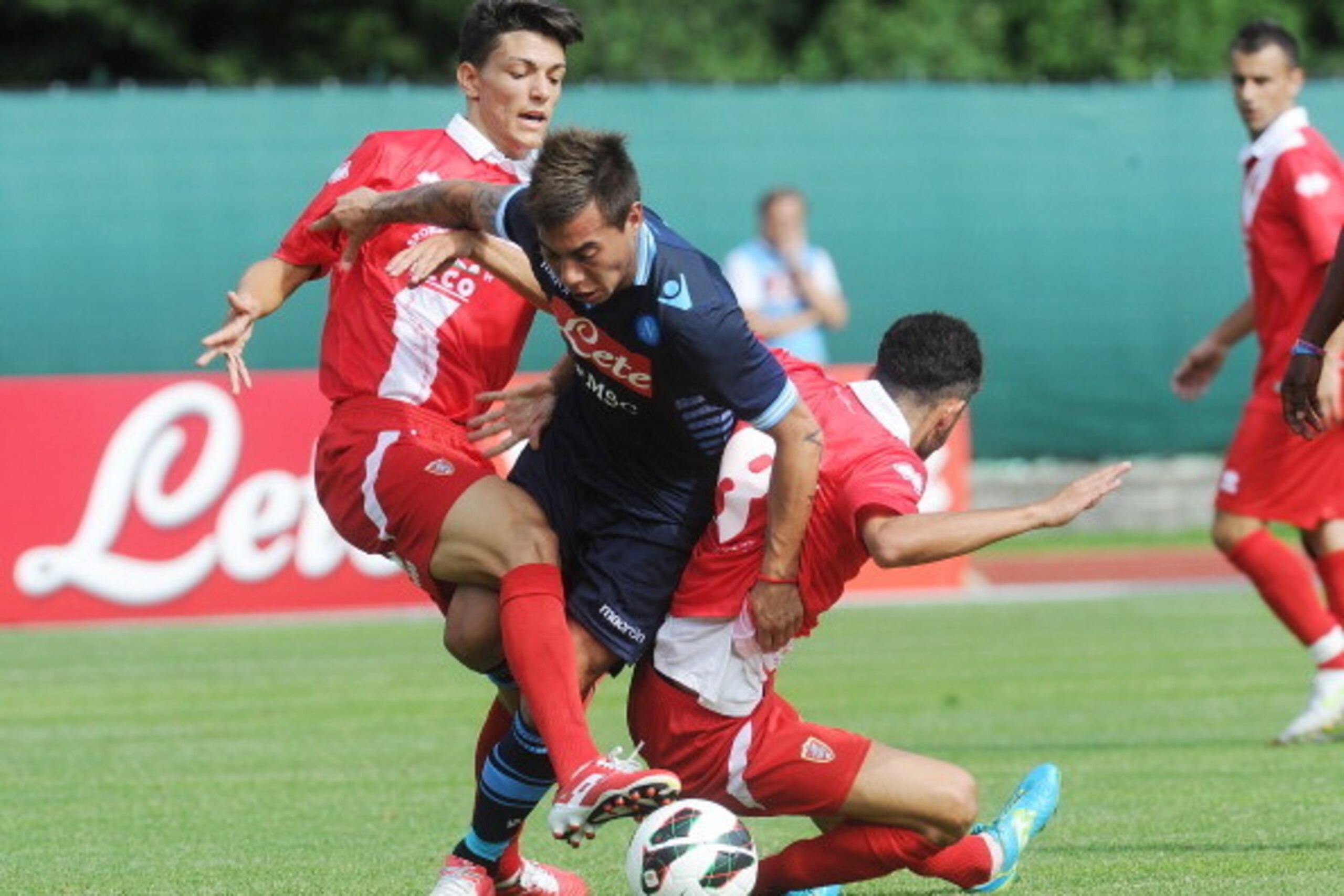 TRENTO, ITALY - JULY 23:  Edoardo Vargas (C)  of Napoli his tackled to Marco Crimi (R)  of Grosseto during the pre-season friendly match between SSC Napoli and US Grosseto on July 23, 2012 in Dimaro near Trento, Italy.  (Photo by Dino Panato/Getty Images)