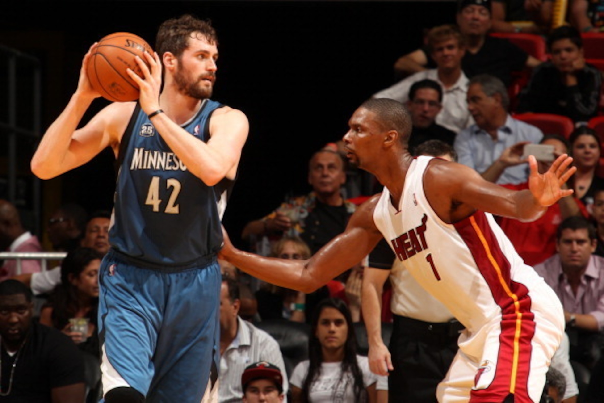 MIAMI, FL - April 4: Kevin Love #42 of the Minnesota Timberwolves handles the ball against Chris Bosh #1 of the Miami Heat at the American Airlines Arena in Miami, Florida on April, 4 2014. NOTE TO USER: User expressly acknowledges and agrees that, by dow MIAMI, FL - April 4: Kevin Love #42 of the Minnesota Timberwolves handles the ball against Chris Bosh #1 of the Miami Heat at the American Airlines Arena in Miami, Florida on April, 4 2014. NOTE TO USER: User expressly acknowledges and agrees that, by dow