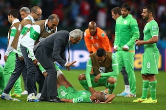 PORTO ALEGRE, BRAZIL - JUNE 30:  Head coach Vahid Halilhodzic of Algeria speaks to Sofiane Feghouli as he lies on the ground prior to the start of extra time during the 2014 FIFA World Cup Brazil Round of 16 match between Germany and Algeria at Estadio Be