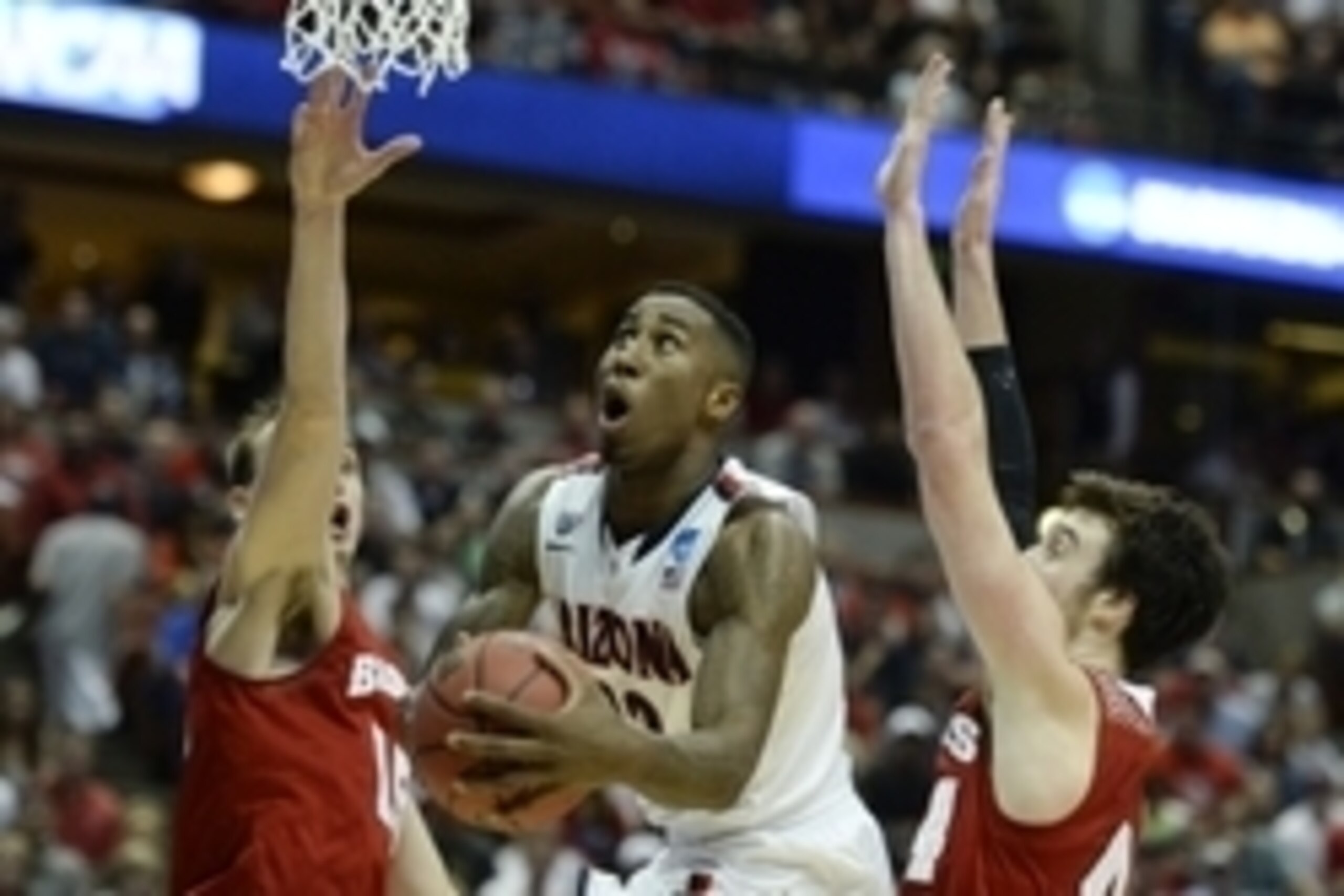Mar 29, 2014; Anaheim, CA, USA; Arizona Wildcats forward Rondae Hollis-Jefferson (center) shoots the ball against Wisconsin Badgers forward Sam Dekker (15) and forward Frank Kaminsky (44) during the second half in the finals of the west regional of the 20