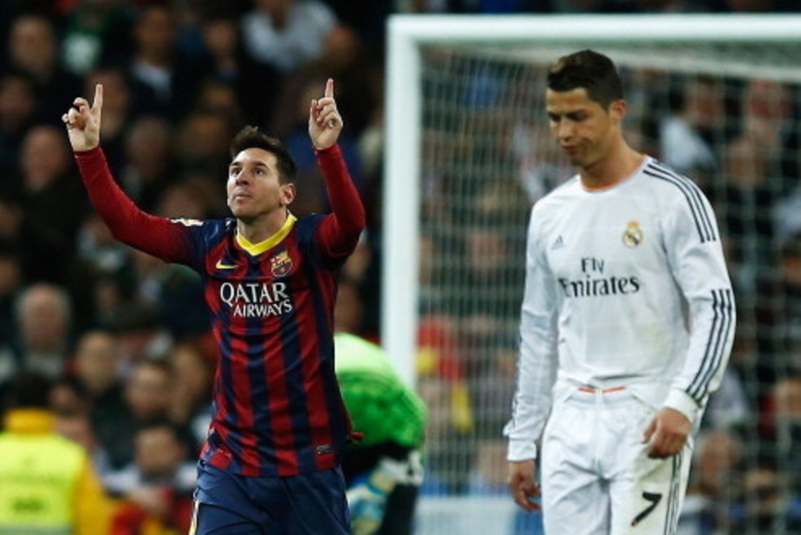 MADRID, SPAIN - MARCH 23:  Lionel Messi of Barcelona celebrates scoring his team's third goal as Cristiano Ronaldo of Real Madrid looks dejected during the La Liga match between Real Madrid CF and FC Barcelona at the Bernabeu on March 23, 2014 in Madrid, 