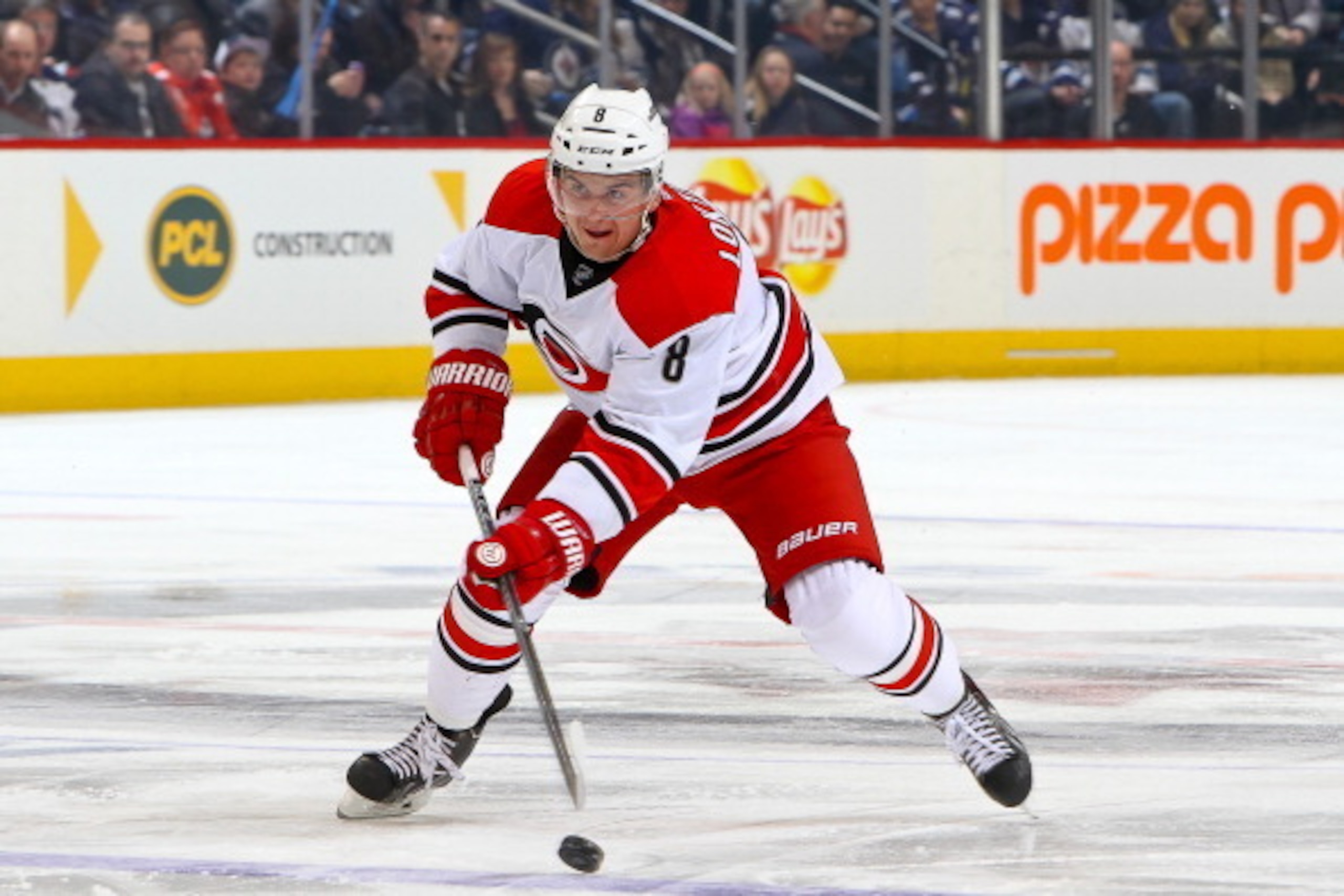 WINNIPEG, MB - MARCH 22: Andrei Loktionov #8 of the Carolina Hurricanes shoots the puck down the ice during first period action against the Winnipeg Jets at the MTS Centre on March 22, 2014 in Winnipeg, Manitoba, Canada. The Canes defeated the Jets 3-2. (