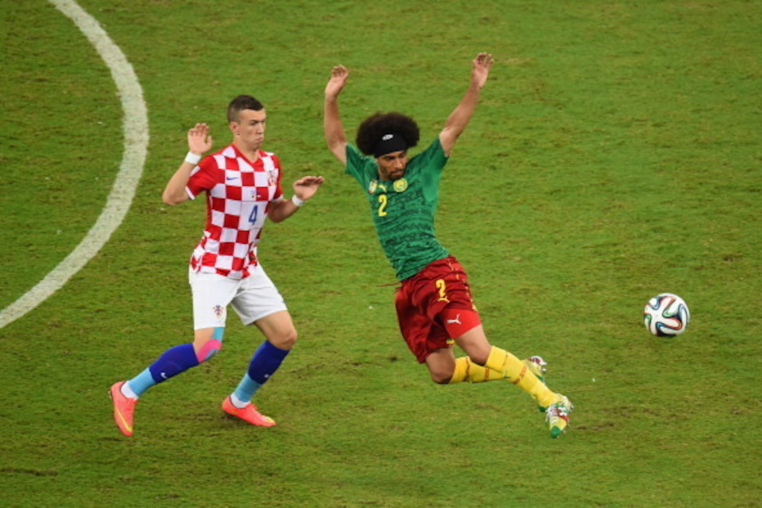 MANAUS, BRAZIL - JUNE 18: Ivan Perisic of Croatia competes for the ball wtih Benoit Assou-Ekotto of Cameroon during the 2014 FIFA World Cup Brazil Group A match between Cameroon and Croatia at Arena Amazonia on June 18, 2014 in Manaus, Brazil.  (Photo by 