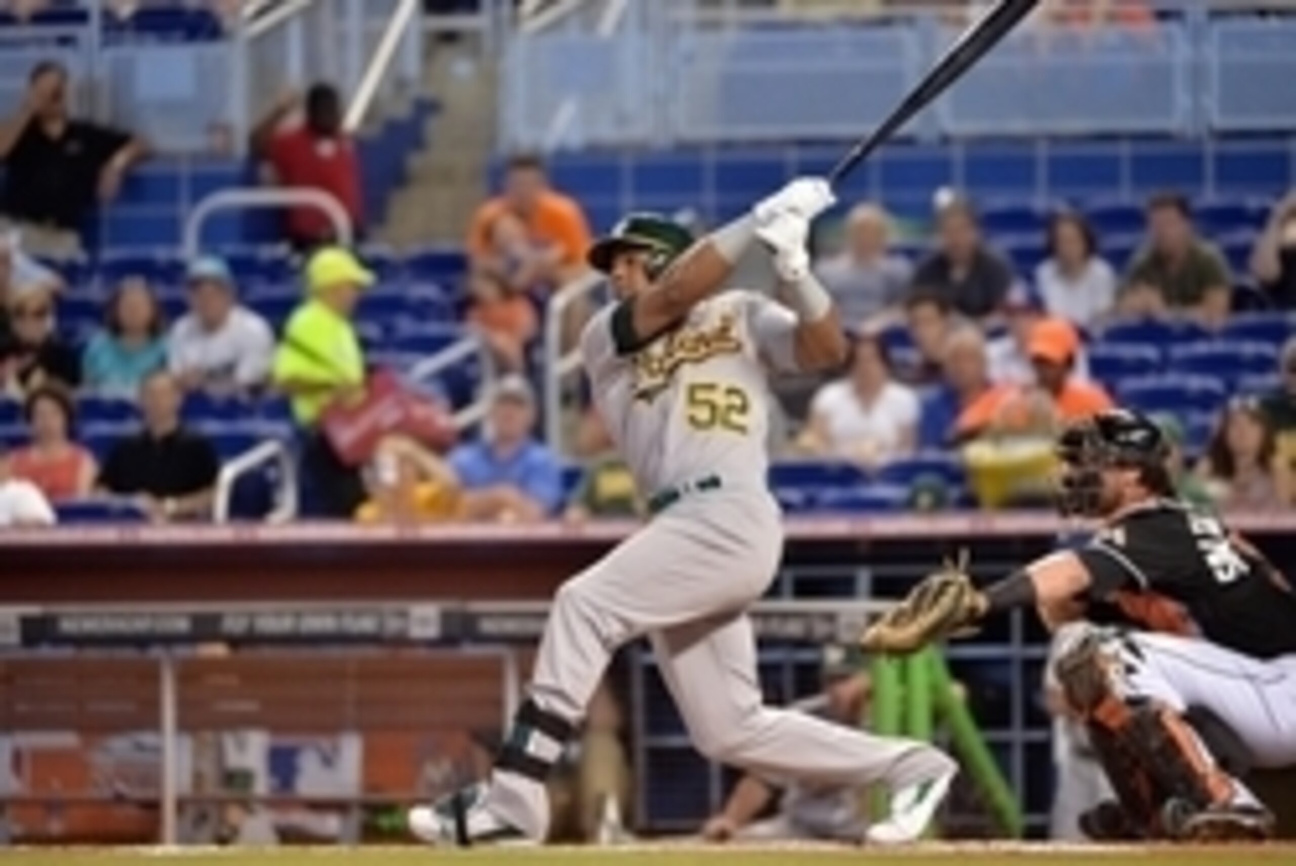 Jun 28, 2014; Miami, FL, USA; Oakland Athletics left fielder Yoenis Cespedes (52) connects for a base hit during the first inning against the Miami Marlins at Marlins Ballpark. Mandatory Credit: Steve Mitchell-USA TODAY Sports