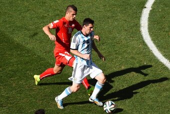 SAO PAULO, BRAZIL - JULY 01: Granit Xhaka of Switzerland challenges Lionel Messi of Argentina during the 2014 FIFA World Cup Brazil Round of 16 match between Argentina and Switzerland at Arena de Sao Paulo on July 1, 2014 in Sao Paulo, Brazil.  (Photo by 