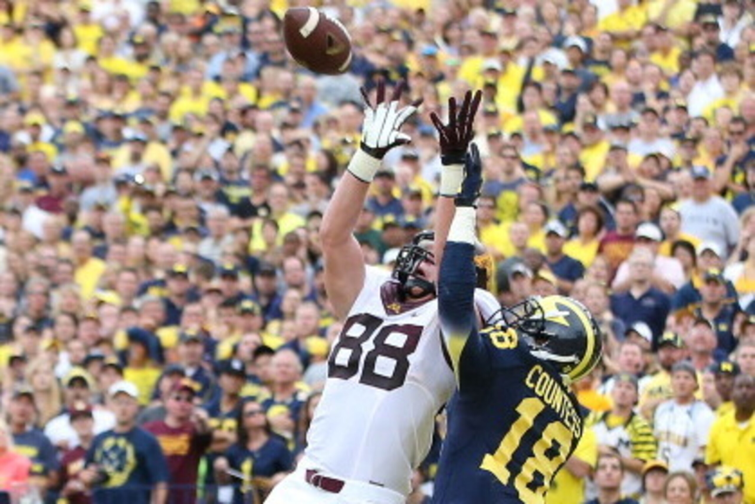 ANN ARBOR, MI - OCTOBER 05:  Maxx Williams #88 of the Minnesota Golden Gophers makes the catch over Blake Countess #18 of the Michigan Wolverines for a first quarter touchdown during the game at Michigan Stadium on October 5, 2013 in Ann Arbor, Michigan. 