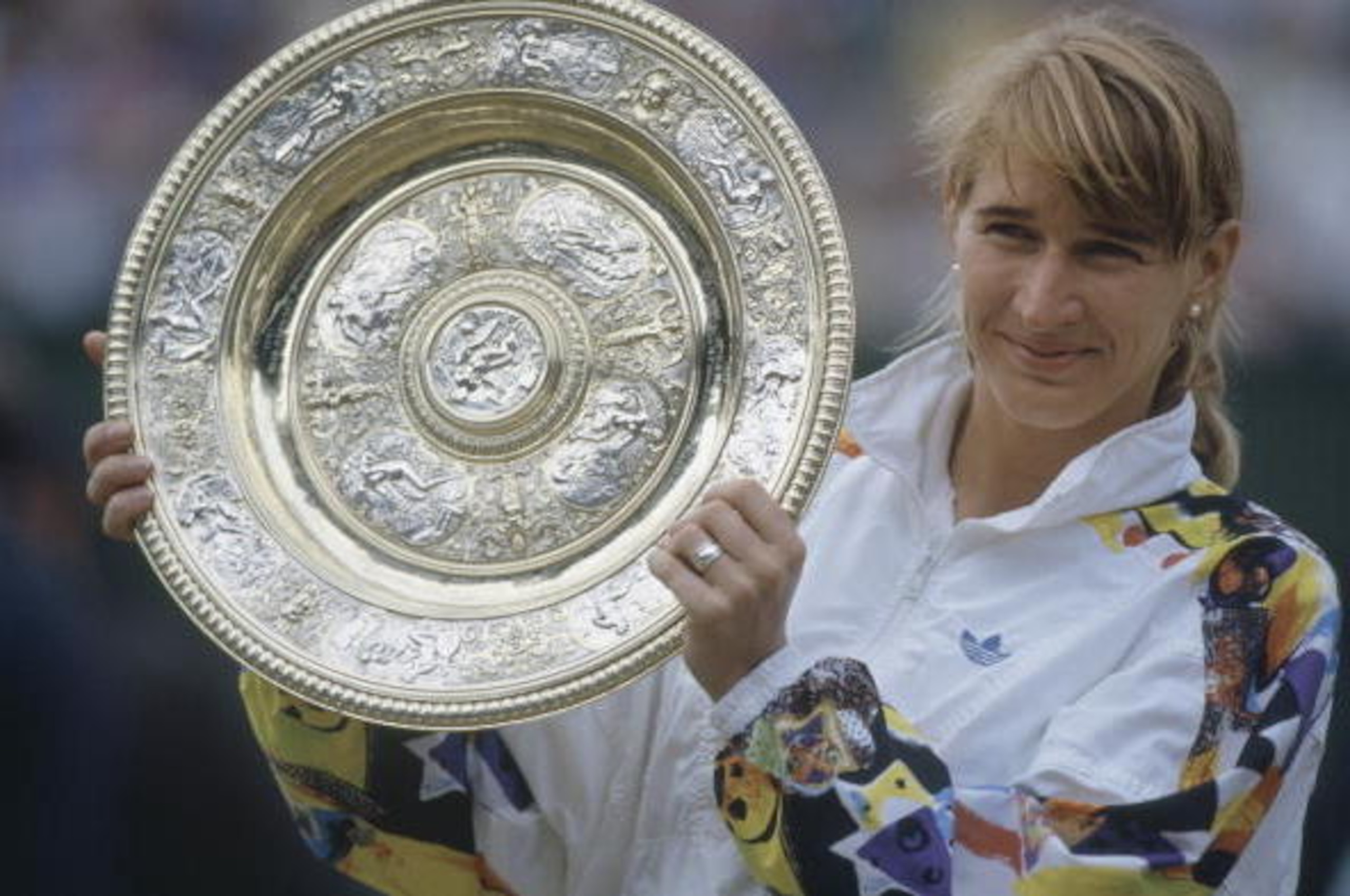 German tennis player Steffi Graf with the trophy after winning the Ladies' Singles final at Wimbledon, London, 4th July 1993. Graf beat Jana Novotna of the Czech Republic 7-6 (6), 1-6, 6-4 to win the title. (Photo by Bob Martin/Getty Images) German tennis player Steffi Graf with the trophy after winning the Ladies' Singles final at Wimbledon, London, 4th July 1993. Graf beat Jana Novotna of the Czech Republic 7-6 (6), 1-6, 6-4 to win the title. (Photo by Bob Martin/Getty Images)