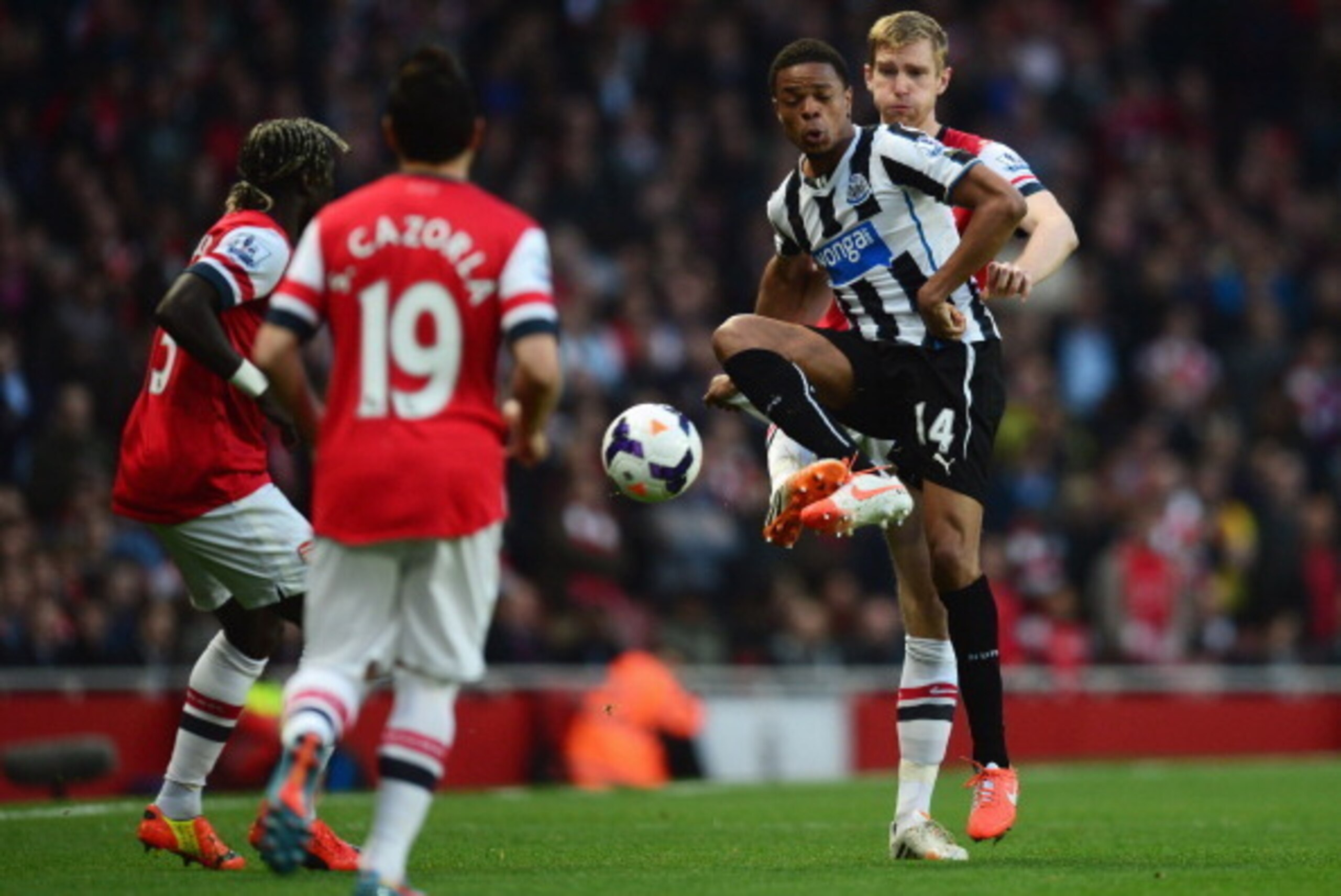 LONDON, ENGLAND - APRIL 28: Loic Remy of Newcastle United controls the ball from Per Mertesacker of Arsenal as Bacary Sagna (L) and Santi Cazorla (2L) look on during the Barclays Premier League match between Arsenal and Newcastle United at Emirates Stadi LONDON, ENGLAND - APRIL 28: Loic Remy of Newcastle United controls the ball from Per Mertesacker of Arsenal as Bacary Sagna (L) and Santi Cazorla (2L) look on during the Barclays Premier League match between Arsenal and Newcastle United at Emirates Stadi