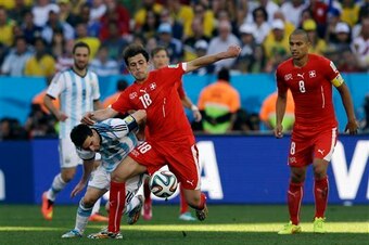 Admir Mehmedi wins the ball from Argentina's Lionel Messi.