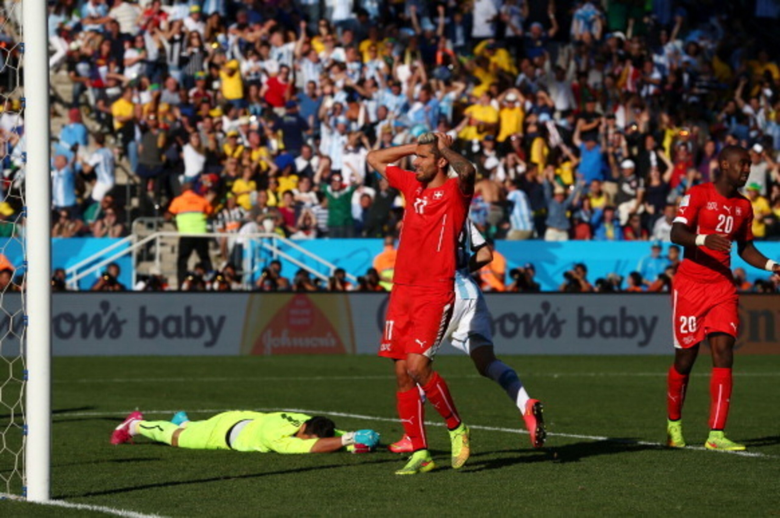 SAO PAULO, BRAZIL - JULY 01:  (L-R) Diego Benaglio, Valon Behrami and Johan Djourou of Switzerland react after allowing a goal to Angel di Maria of Argentina (not pictured) in extra time during the 2014 FIFA World Cup Brazil Round of 16 match between Arge