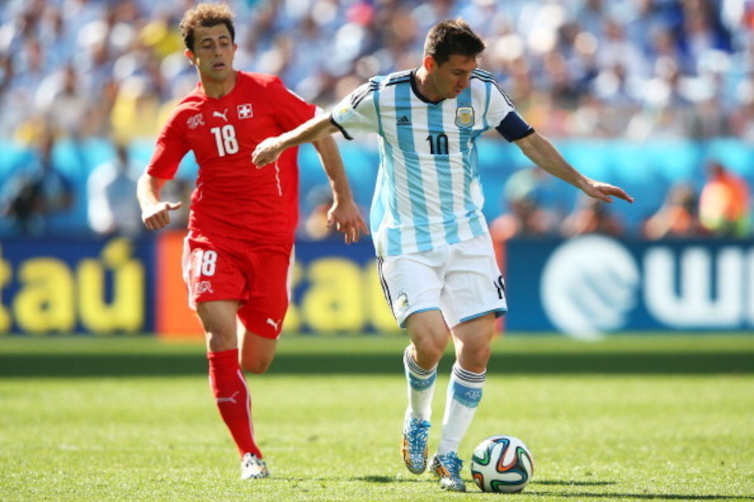 SAO PAULO, BRAZIL - JULY 01:  Lionel Messi of Argentina controls the ball as Admir Mehmedi of Switzerland gives chase during the 2014 FIFA World Cup Brazil Round of 16 match between Argentina and Switzerland at Arena de Sao Paulo on July 1, 2014 in Sao Pa