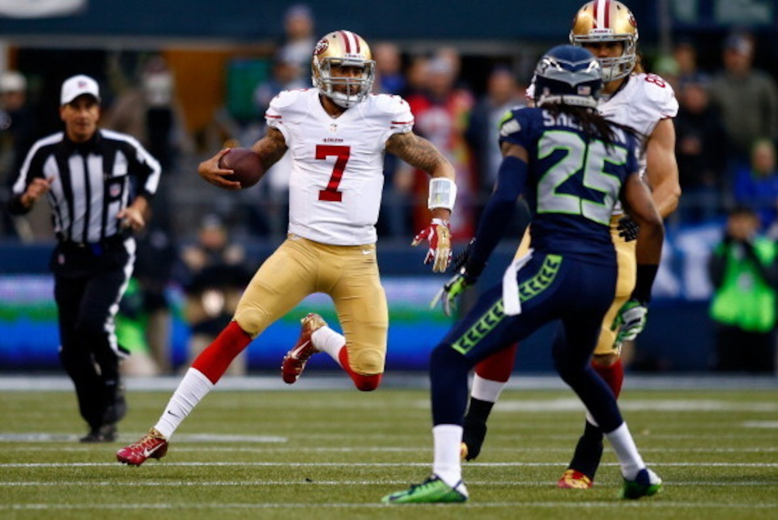 SEATTLE, WA - JANUARY 19:  Quarterback Colin Kaepernick #7 of the San Francisco 49ers runs the ball in the first half against the Seattle Seahawks during the 2014 NFC Championship at CenturyLink Field on January 19, 2014 in Seattle, Washington.  (Photo by