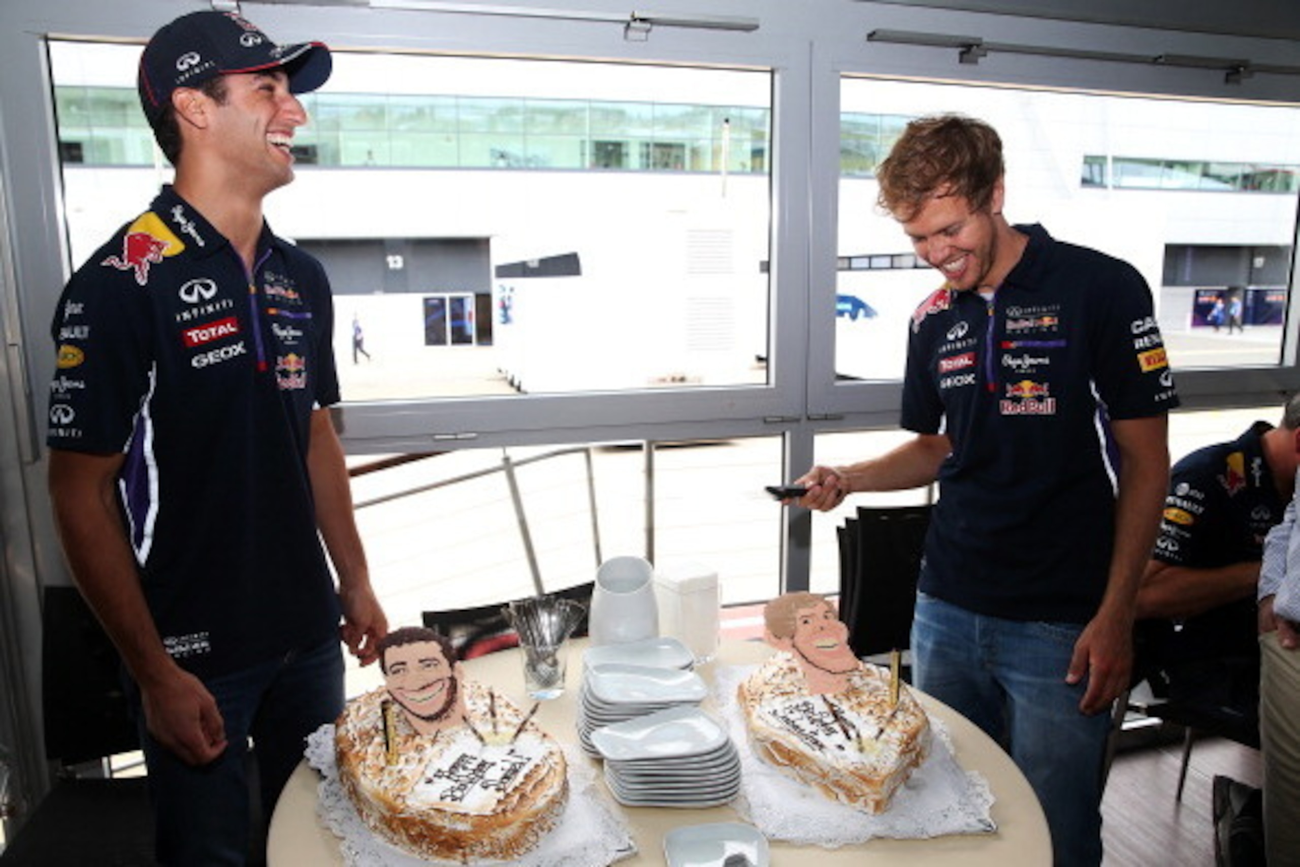 NORTHAMPTON, ENGLAND - JULY 03:  Sebastian Vettel (R) of Germany and Infiniti Red Bull Racing and Daniel Ricciardo of Australia and Infiniti Red Bull Racing laugh as they are presented with their birthday cakes during previews ahead of the British Formula