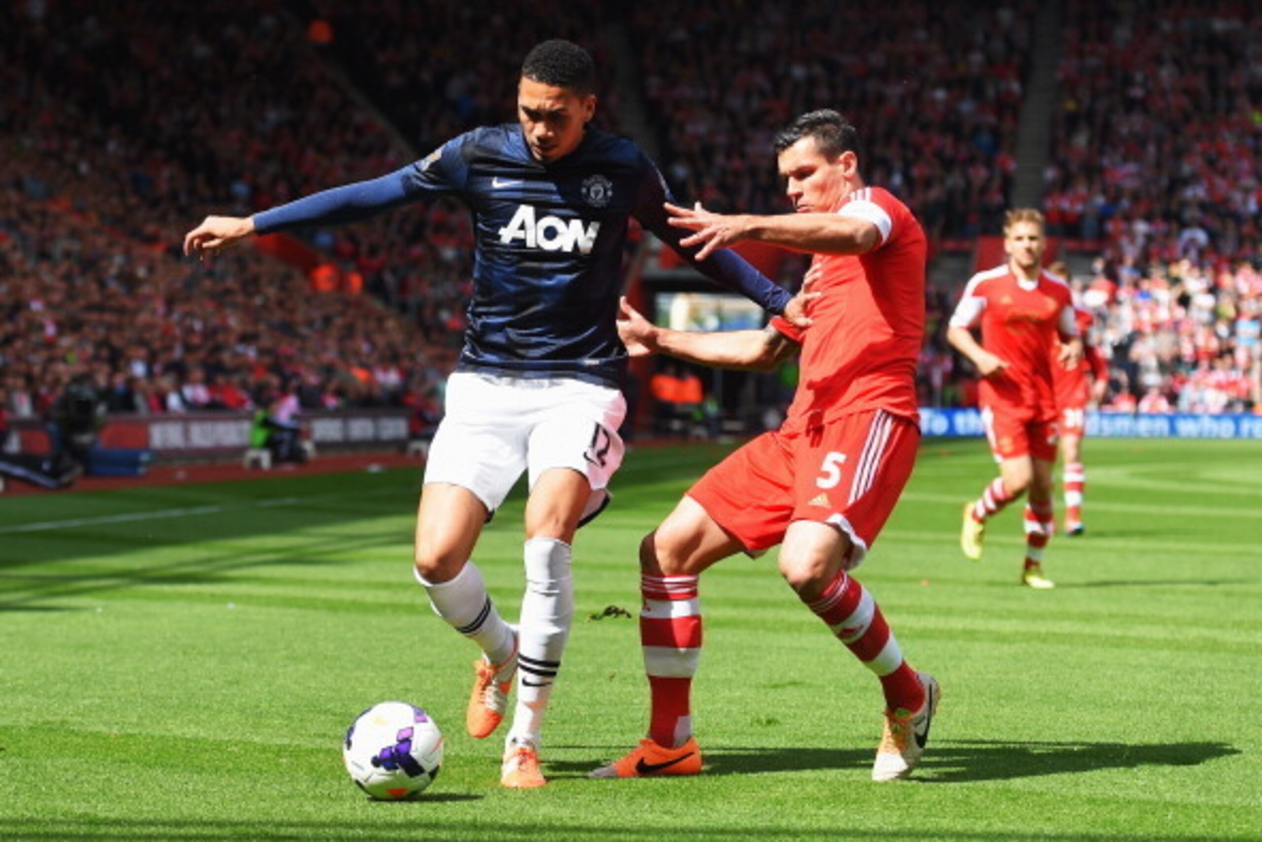 SOUTHAMPTON, ENGLAND - MAY 11:  Chris Smalling (L) of Manchester United holds off Dejan Lovren (R) of Southampton during the Barclays Premier League match between Southampton and Manchester United at St Mary's Stadium on May 11, 2014 in Southampton, Engla