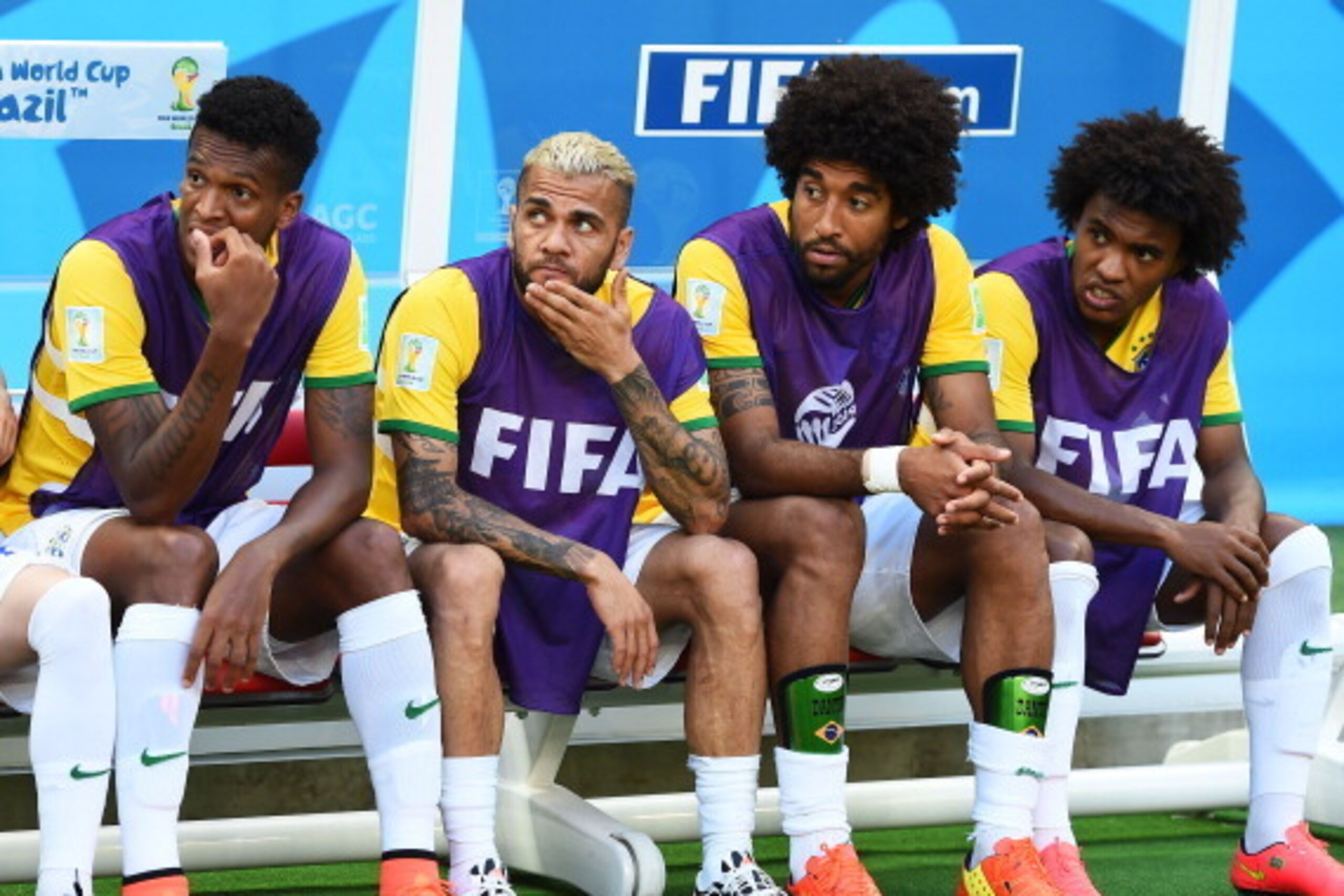 FORTALEZA, BRAZIL - JULY 04:  Jo, Dani Alves, Dante and Willian of Brazil look on from the bench prior to the 2014 FIFA World Cup Brazil Quarter Final match between Brazil and Colombia at Castelao on July 4, 2014 in Fortaleza, Brazil.  (Photo by Laurence 