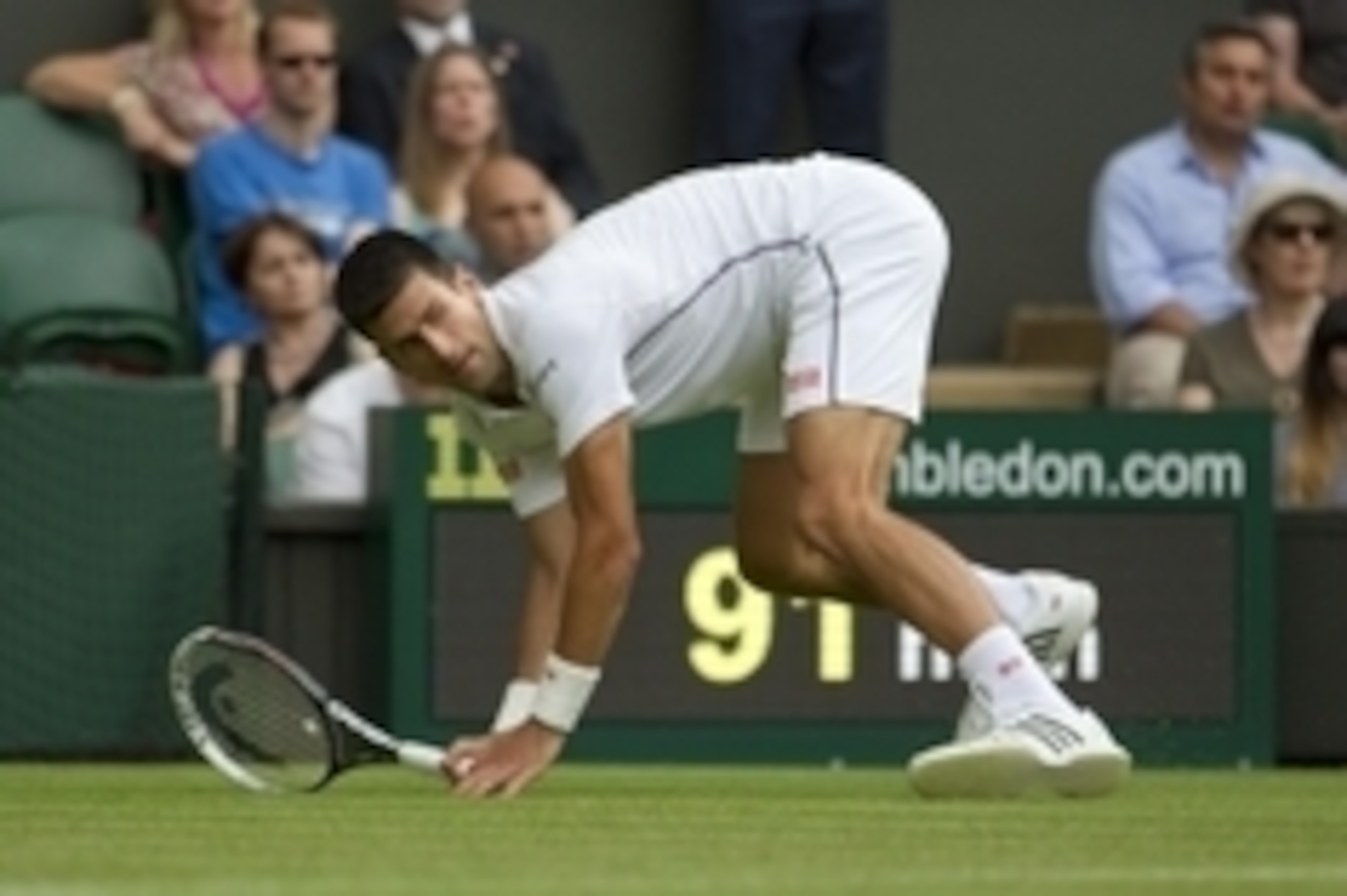 Jun 23, 2014; London, United Kingdom; Novak Djokovic (SRB) slips on the grass during his match against Andrey Golubev (KAZ) on day one of the 2014 Wimbledon Championships at the All England Lawn and Tennis Club. Mandatory Credit: Susan Mullane-USA TODAY S
