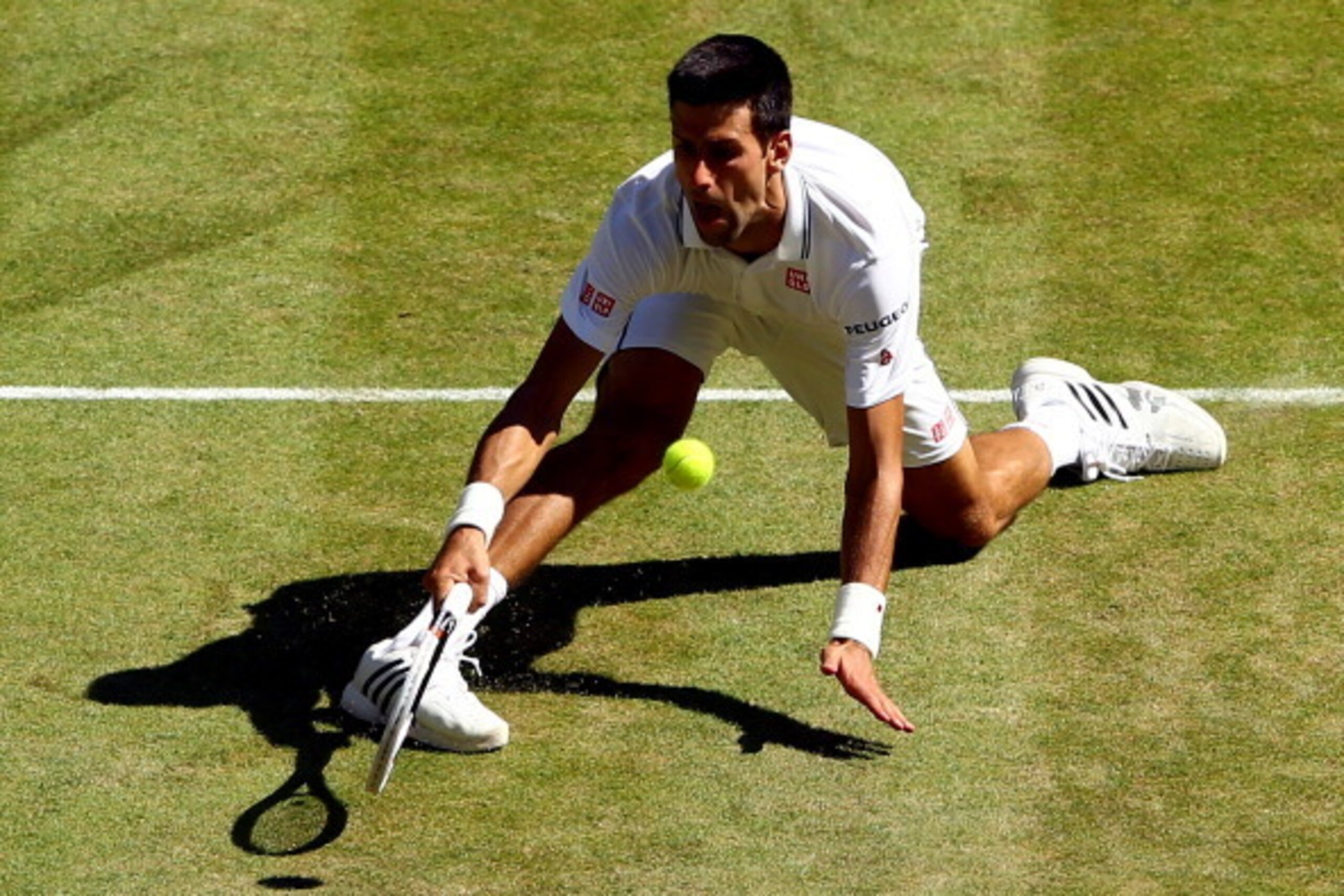 LONDON, ENGLAND - JULY 04:  Novak Djokovic of Serbia stretches to make a return during his Gentlemen's Singles semi-final match against Grigor Dimitrov of Bulgaria on day eleven of the Wimbledon Lawn Tennis Championships at the All England Lawn Tennis and