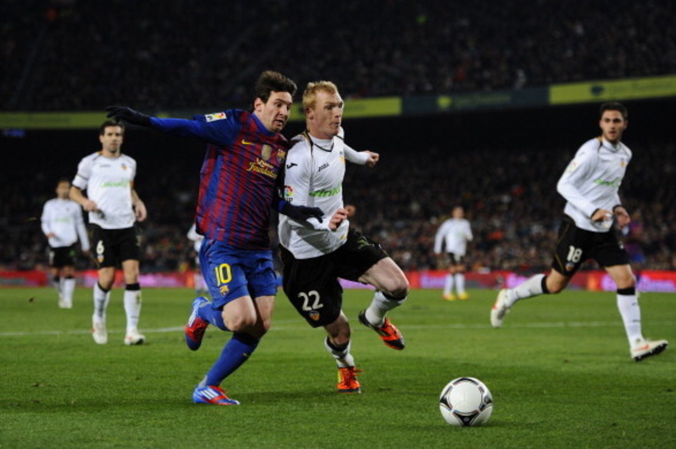 BARCELONA, SPAIN - FEBRUARY 08:  Lionel Messi of FC Barcelona (L) duels for the ball with Jeremy Mathieu of Valencia during the Copa del Rey Semi Final 2nd leg match between FC Barcelona and Valencia  at Nou Camp on February 8, 2012 in Barcelona, Spain.  