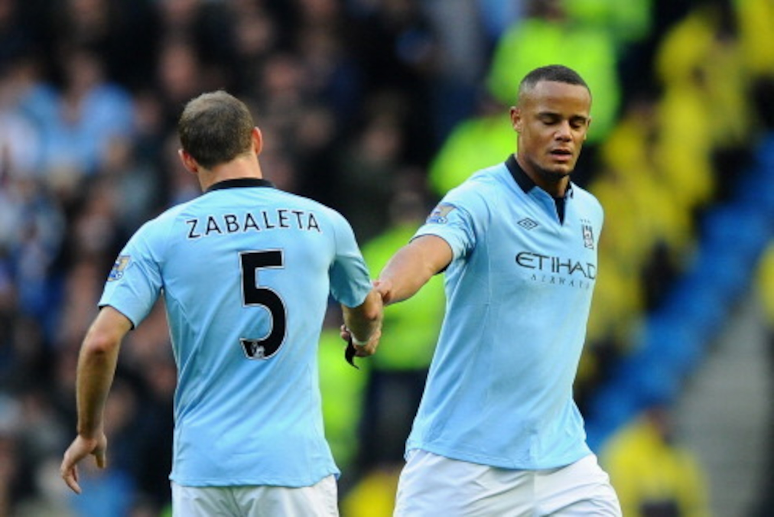 MANCHESTER, ENGLAND - DECEMBER 09:  Vincent Kompany of Manchester City hands the Captain's armband to team-mate Pablo Zabaleta during the Barclays Premier League match between Manchester City and Manchester United at the Etihad Stadium on December 9, 2012