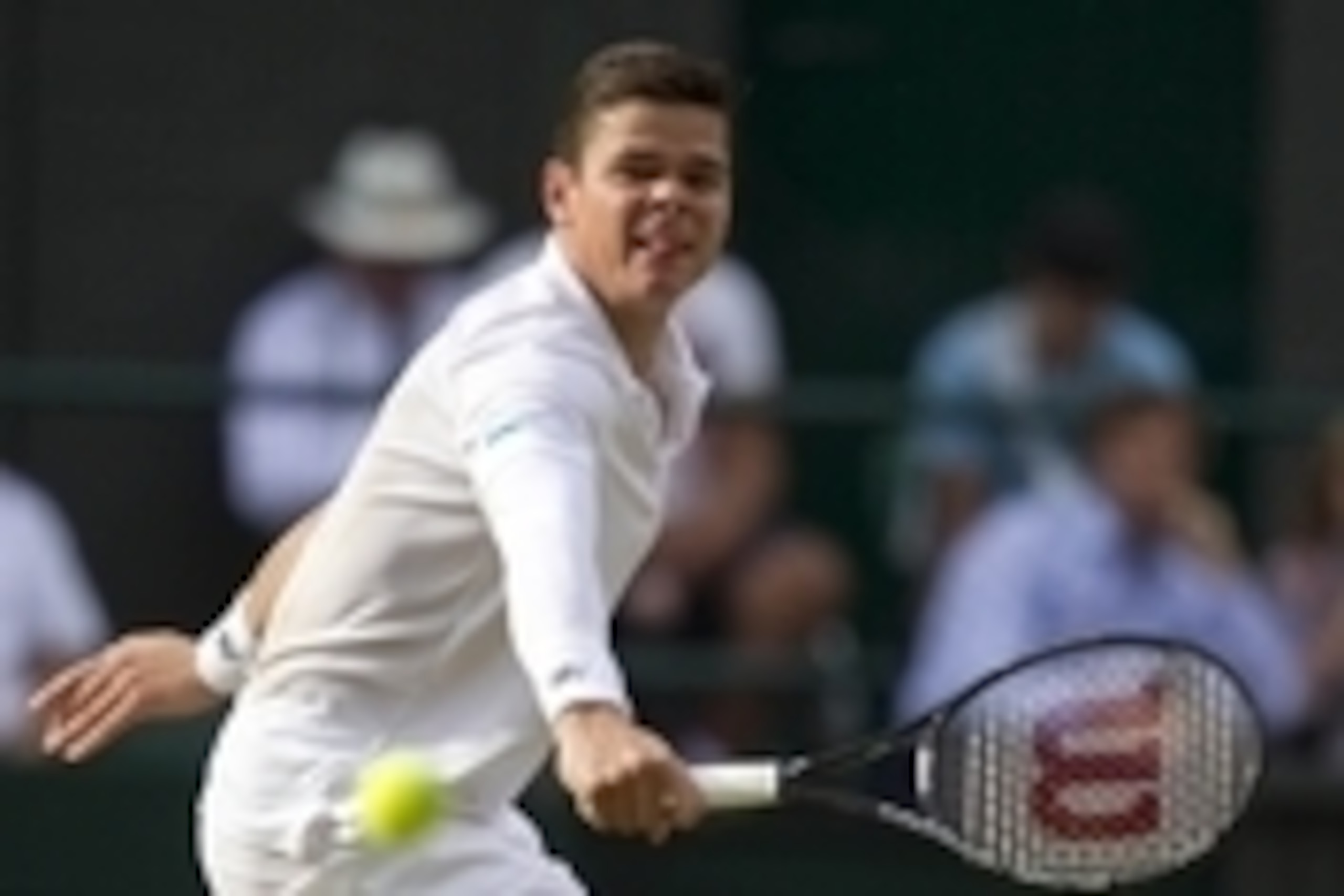 Jul 4, 2014; London, United Kingdom; Milos Raonic (CAN) in action during his match against Roger Federer (SUI) on day 11 of the 2014 Wimbledon Championships at the All England Lawn and Tennis Club. Mandatory Credit: Susan Mullane-USA TODAY Sports