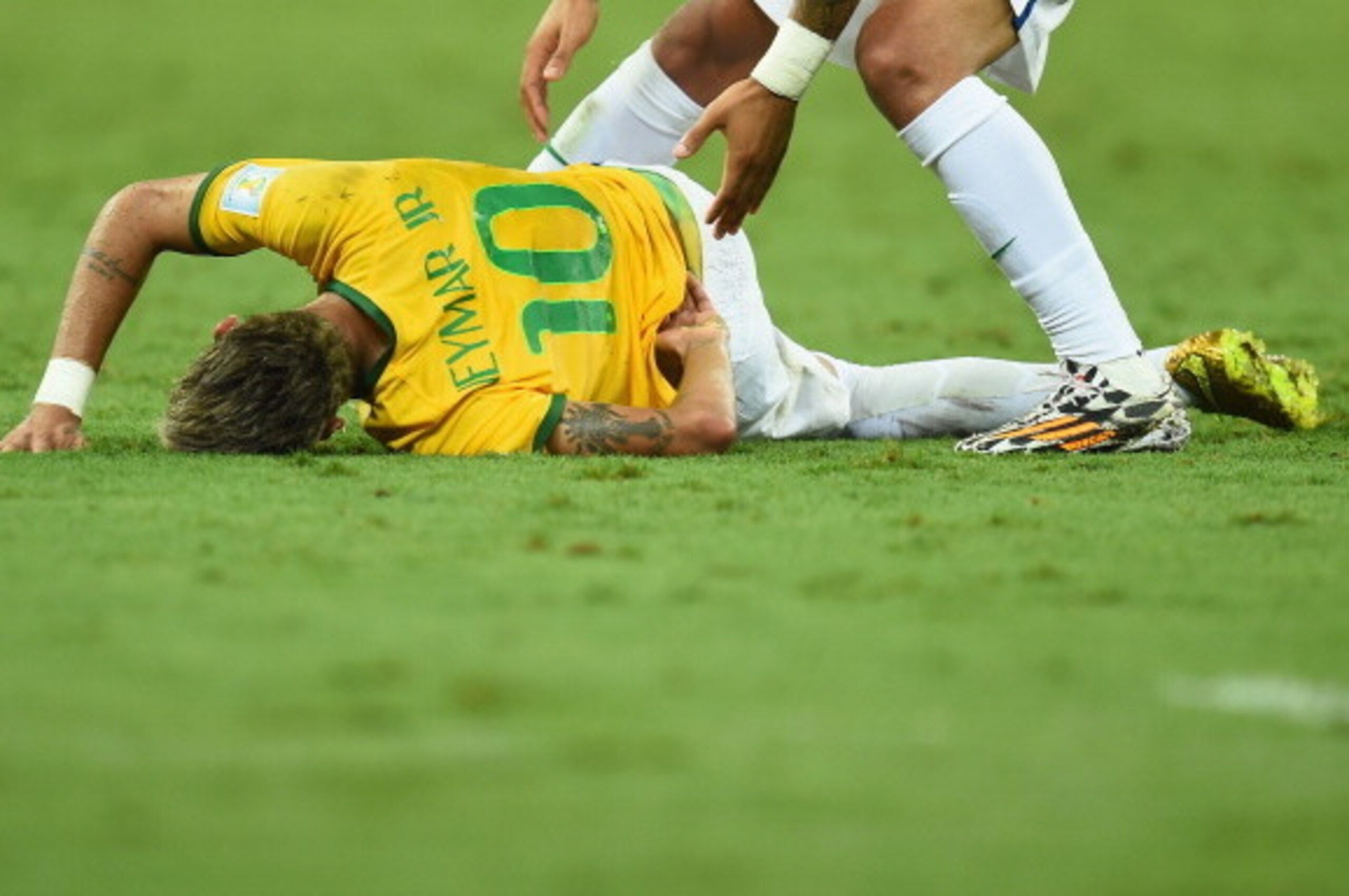 FORTALEZA, BRAZIL - JULY 04:  Neymar of Brazil lies on the field after a challenge as teammate Marcelo reacts during the 2014 FIFA World Cup Brazil Quarter Final match between Brazil and Colombia at Castelao on July 4, 2014 in Fortaleza, Brazil.  (Photo b