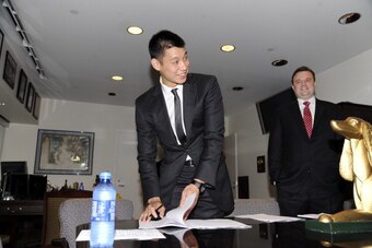 HOUSTON, TX - JULY 19: Jeremy Lin #7 of the Houston Rockets signs his contract prior to a press conference on July 19, 2012 at the Toyota Center in Houston, Texas. NOTE TO USER: User expressly acknowledges and agrees that, by downloading and or using this