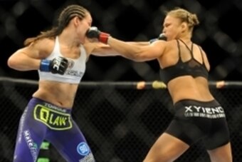 Jul 5, 2014; Las Vegas, NV, USA; Ronda Rousey (red gloves) trades punches with Alexis Davis (blue gloves) during a women's bantamweight title bout at Mandalay Bay Events Center. Mandatory Credit: Stephen R. Sylvanie-USA TODAY Sports