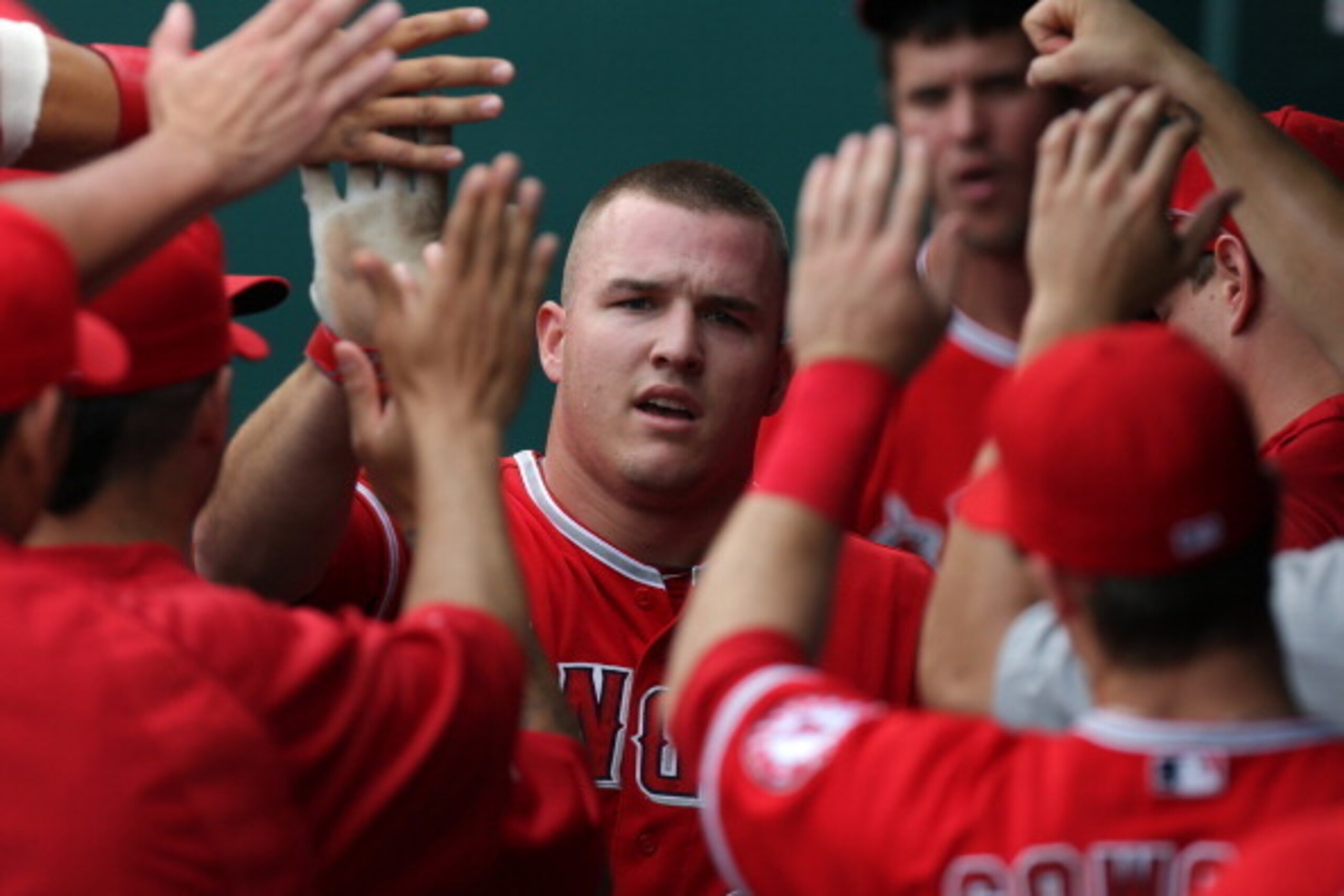 KANSAS CITY, MO - JUNE 29:  Mike Trout #27 of the Los Angeles Angels of Anaheim celebrates with teammates after scoring in the first inning during a game against the Kansas City Royals at Kauffman Stadium on June 29, 2014 in Kansas City, Missouri. (Photo 
