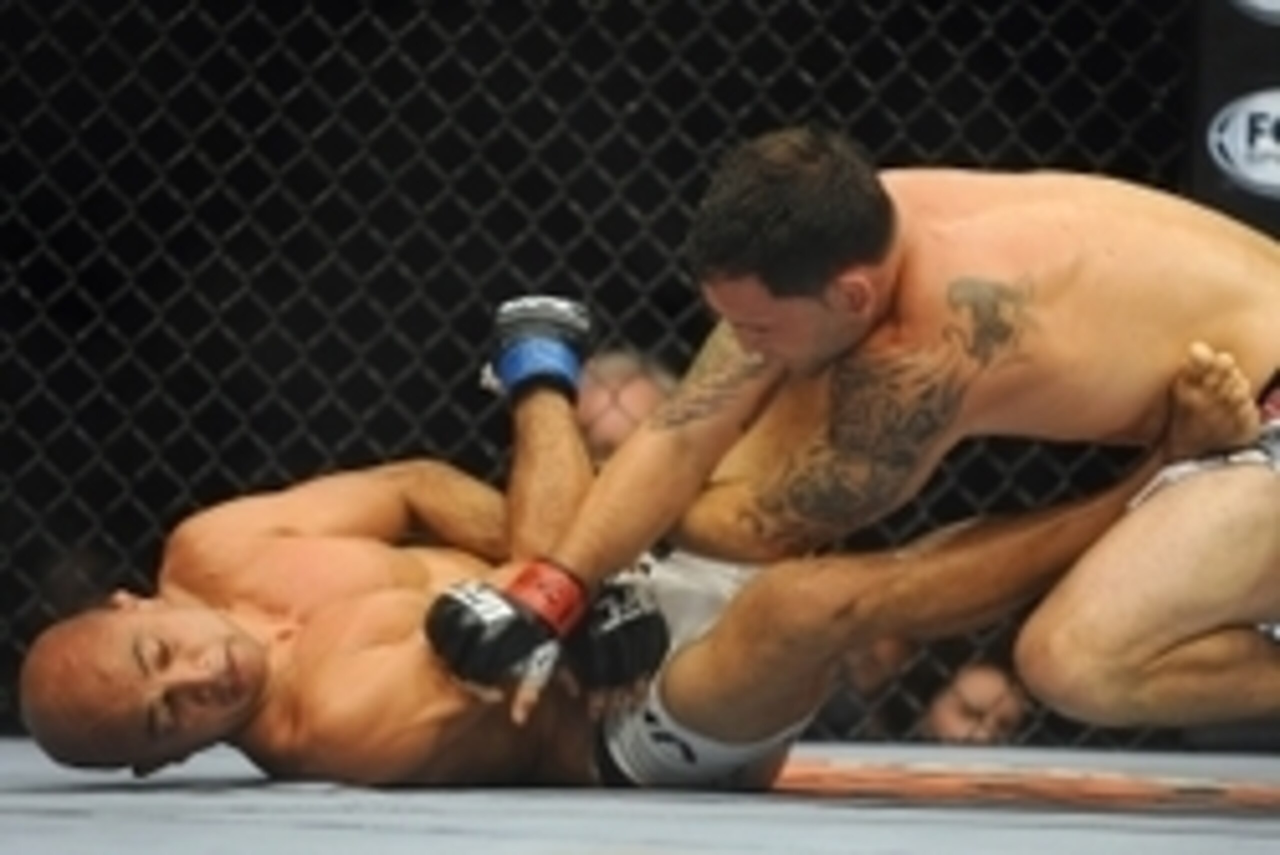 Jul 6, 2014; Las Vegas, NV, USA; Frankie Edgar (red gloves) throws punches at a prone B.J. Penn (blue gloves) during their featherweight bout at Mandalay Bay Events Center. Mandatory Credit: Stephen R. Sylvanie-USA TODAY Sports