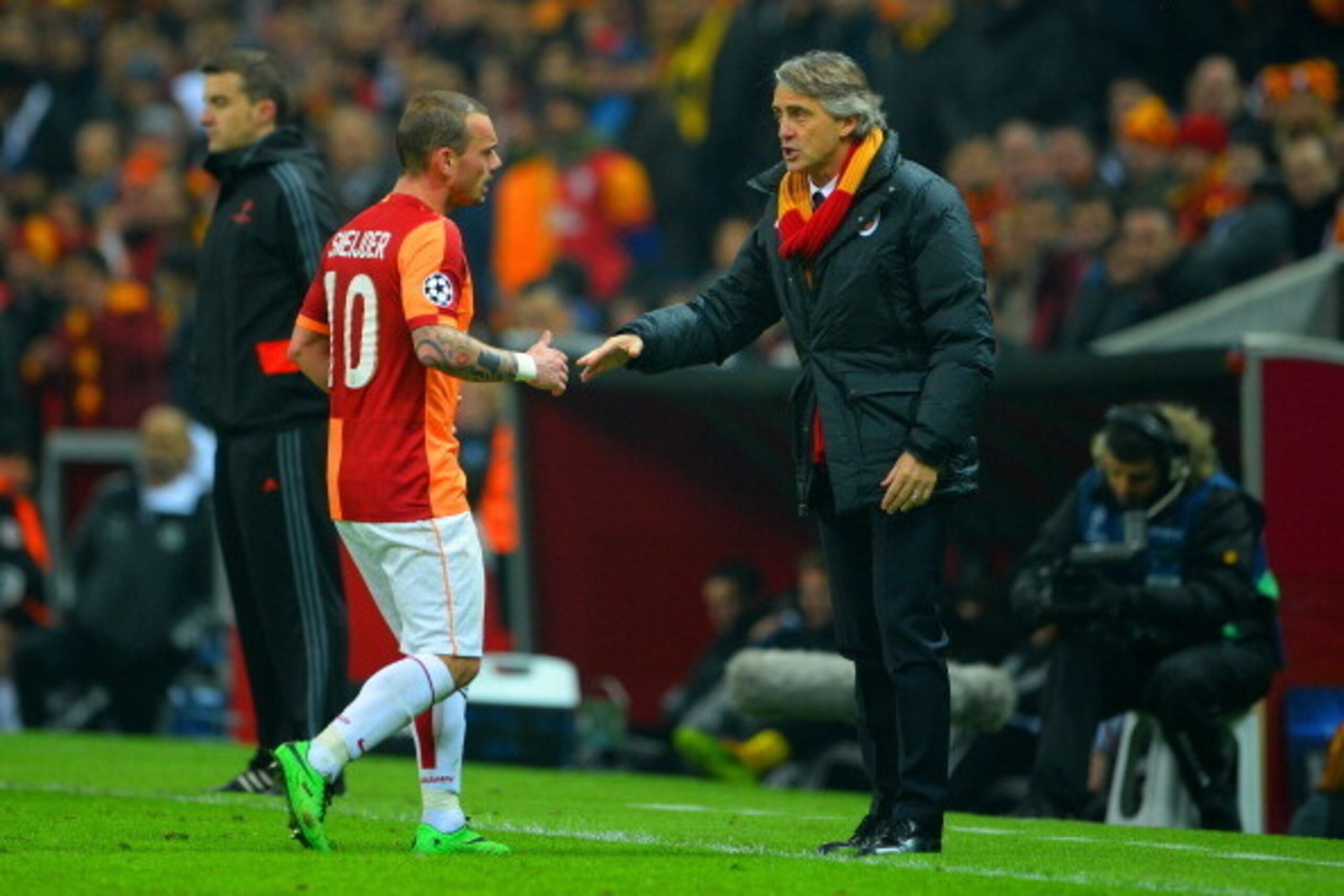 ISTANBUL, TURKEY - FEBRUARY 26:  Wesley Sneijder of Galatasaray speaks to Head Coach Roberto Mancini of Galatasaray during the UEFA Champions League Round of 16 first leg match between Galatasaray AS and Chelsea at Ali Sami Yen Arena on February 26, 2014 