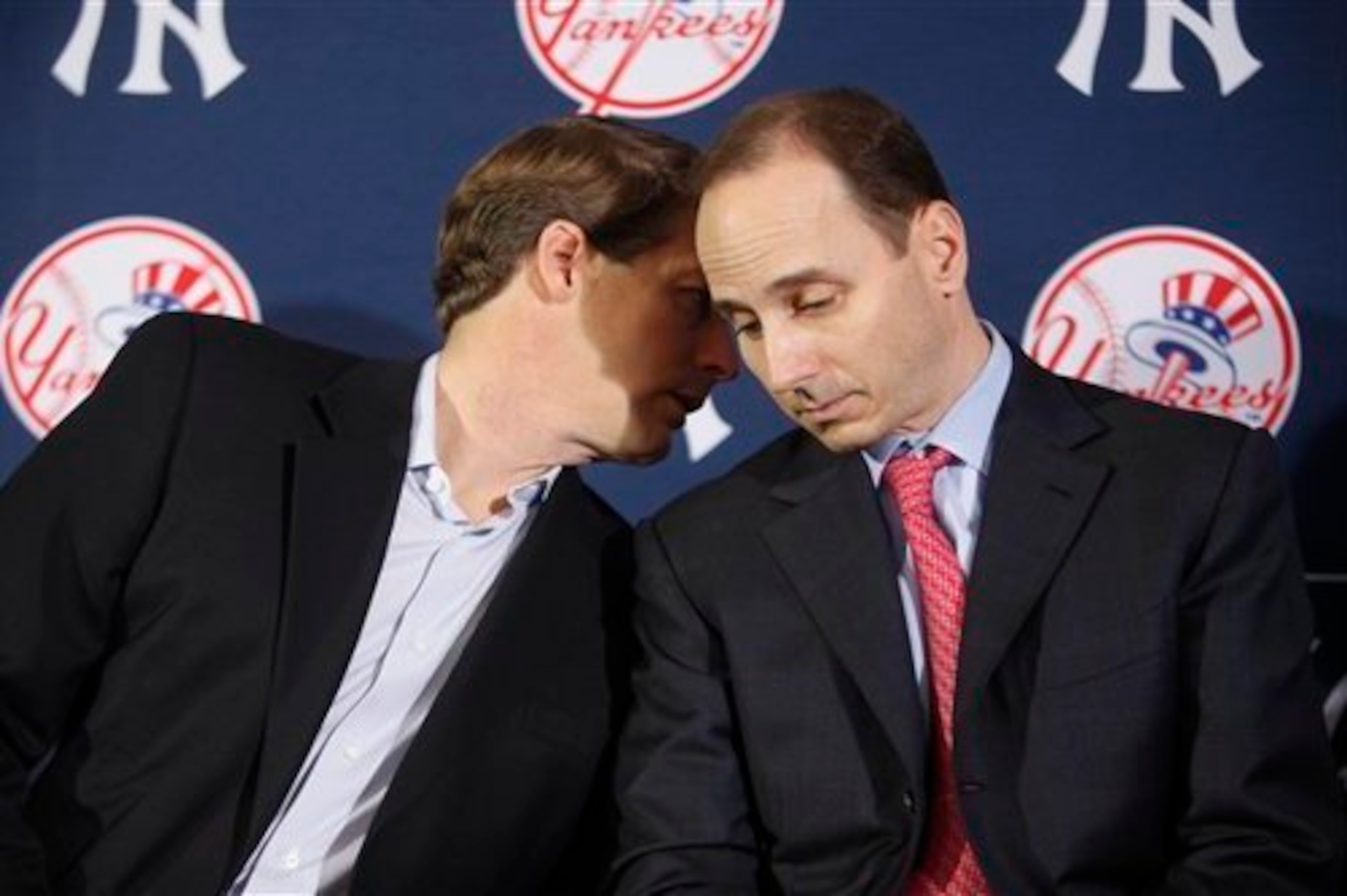 Managing general partner/co-chairperson Hal Steinbrenner (left) leans in to chat with Cashman in 2009.