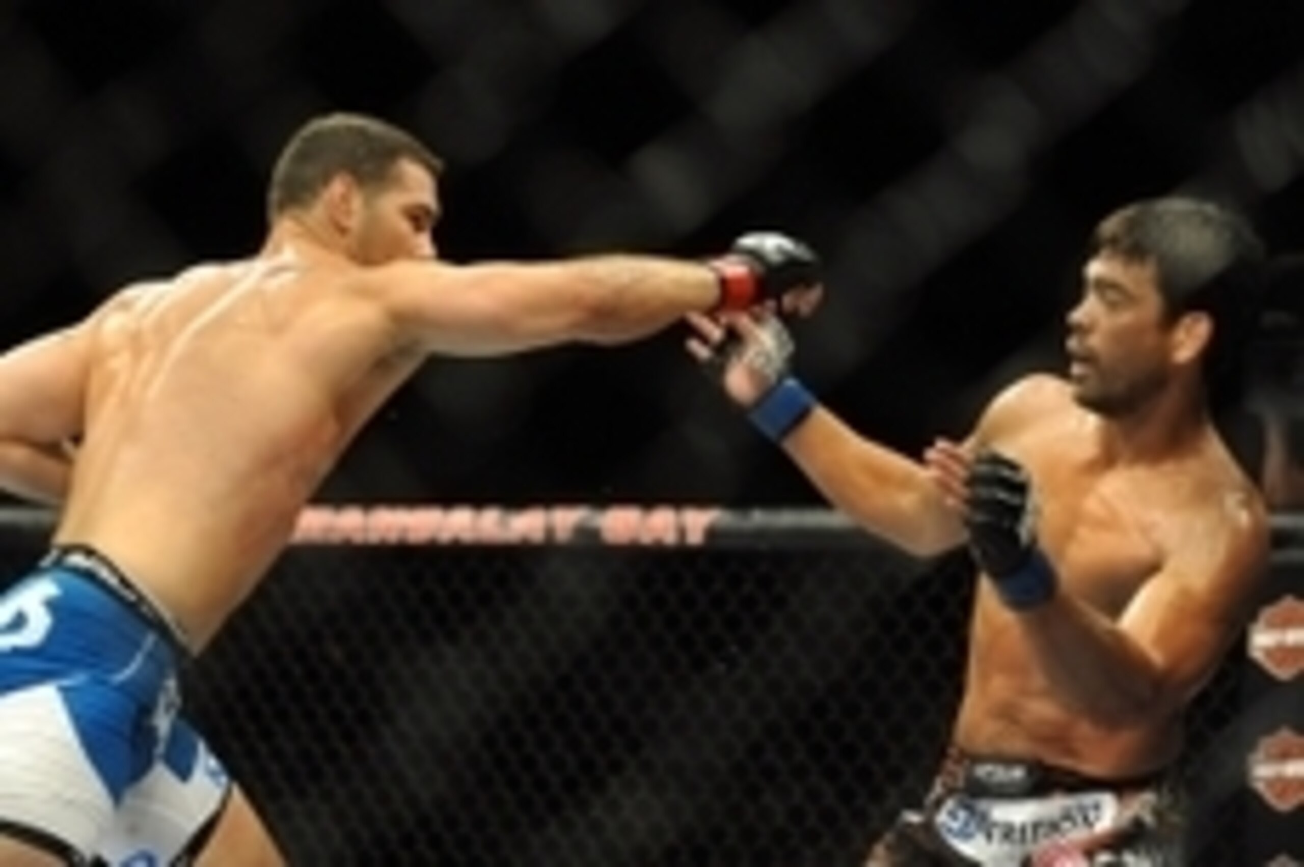 Jul 5, 2014; Las Vegas, NV, USA; Lyoto Machida (blue gloves) dodges a punch by Chris Weidman (red gloves) during a middleweight title fight at Mandalay Bay Events Center. Mandatory Credit: Stephen R. Sylvanie-USA TODAY Sports