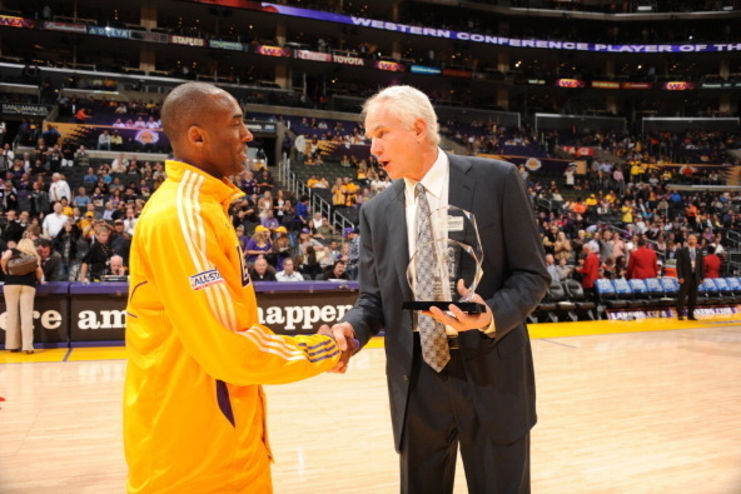 LOS ANGELES, CA - APRIL 12:  General Manager Mitch Kupchak of the Los Angeles Lakers presents Kobe Byryant #24 with the Kia Performance Western Conference Player of the Month award for March 2011 before a game against the San Antonio Spurs at Staples Cent