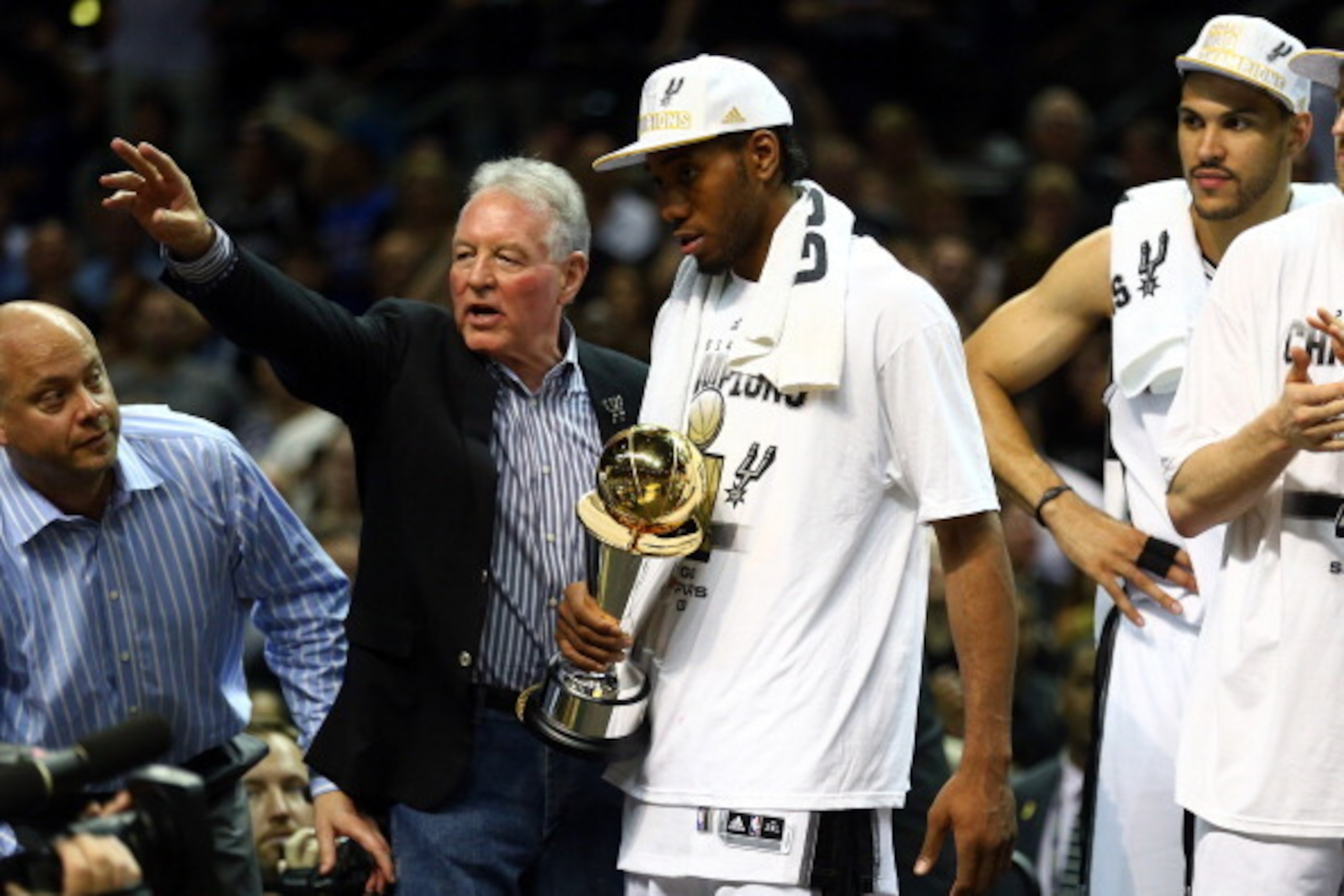 SAN ANTONIO, TX - JUNE 15:  Kawhi Leonard #2 of the San Antonio Spurs celebrates with the Bill Russell NBA Finals Most Valuable Player Award and owner Peter Holt after defeating the Miami Heat in Game Five of the 2014 NBA Finals at the AT&T Center on June