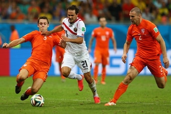 SALVADOR, BRAZIL - JULY 05:  Stefan De Vrij (L)  of the Netherlands tackles Marcos Urena of Costa Rica as Ron Vlaar closes in during the 2014 FIFA World Cup Brazil Quarter Final match between the Netherlands and Costa Rica at Arena Fonte Nova on July 5, 2
