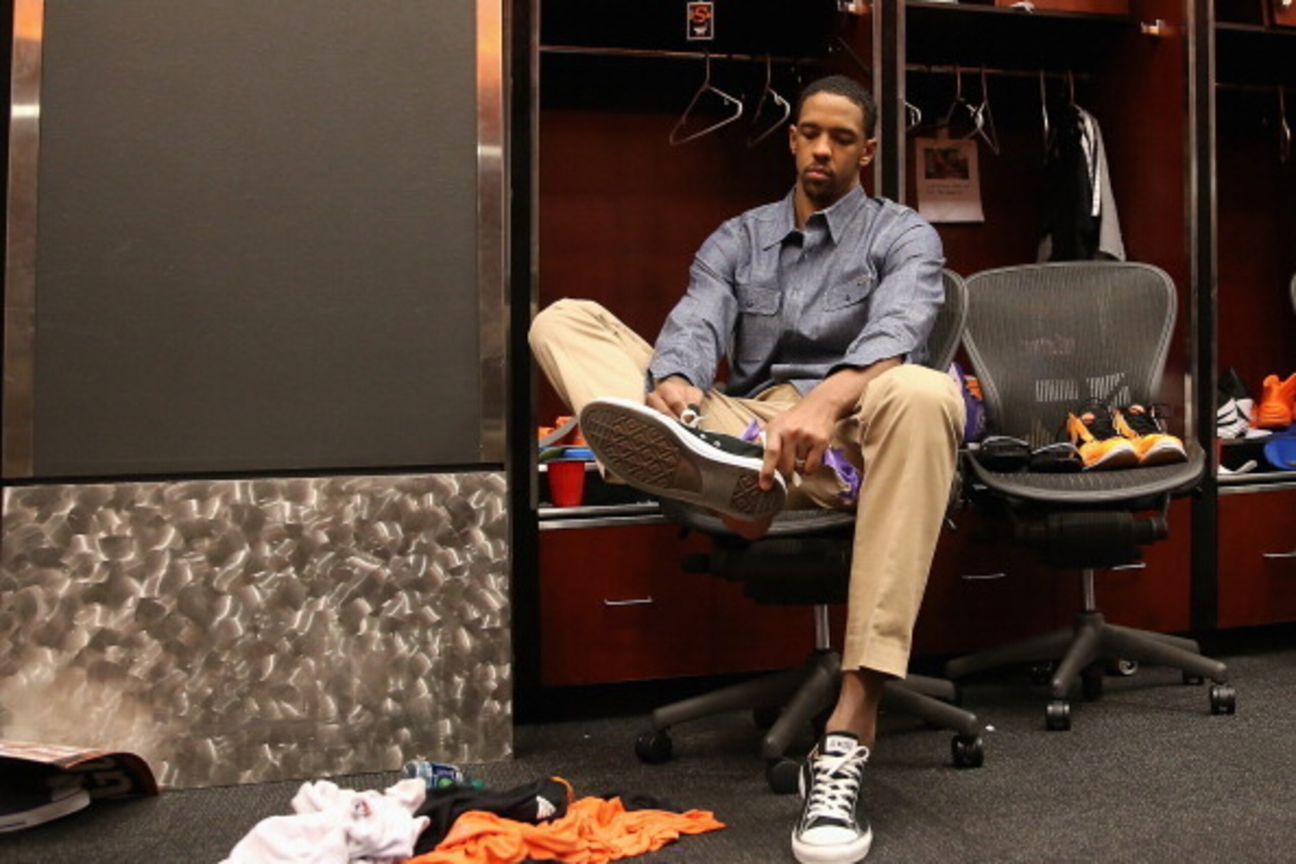 PHOENIX, AZ - APRIL 14:  Channing Frye #8 of the Phoenix Suns takes off his shoes in the locker room following the NBA game against the Memphis Grizzlies at US Airways Center on April 14, 2014 in Phoenix, Arizona.  The Grizzlies defeated the Suns 97-91.  