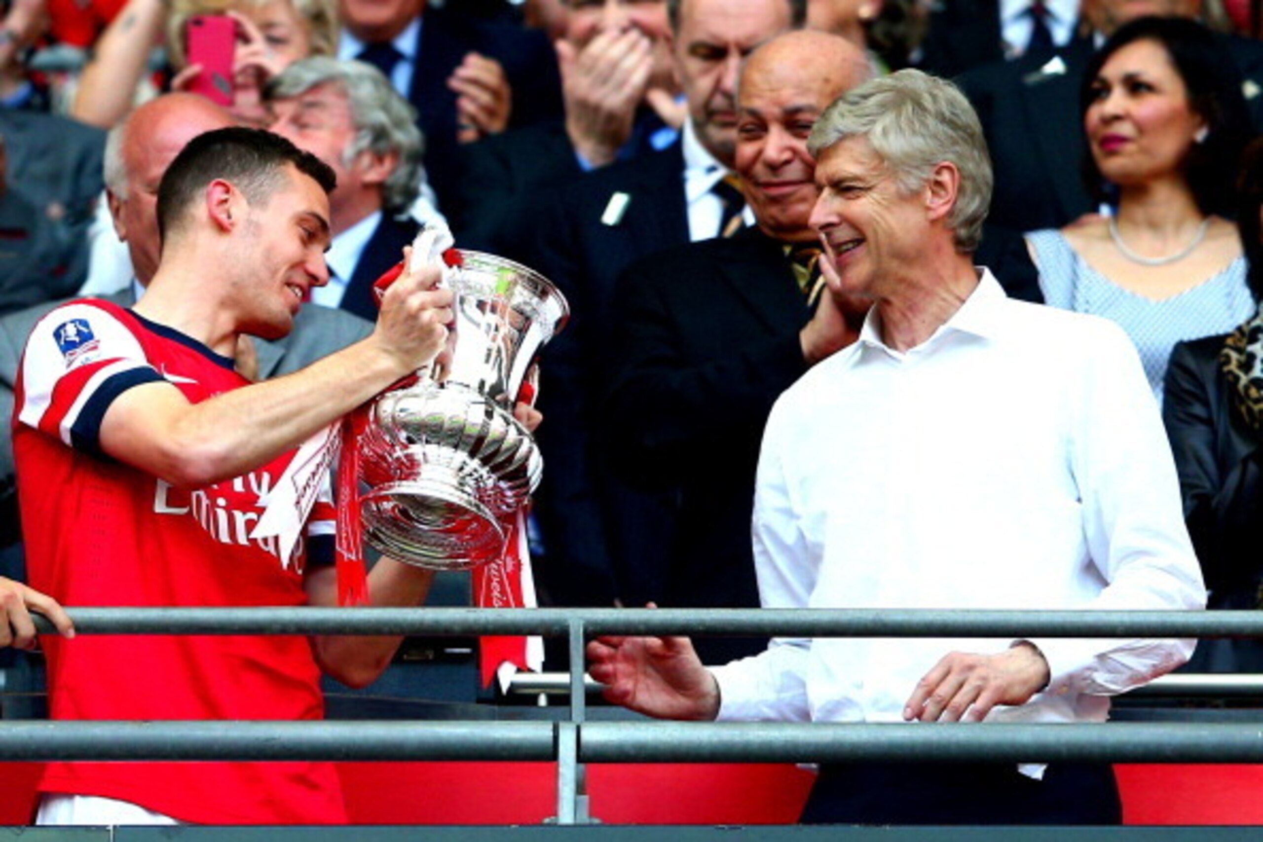 LONDON, ENGLAND - MAY 17:  Captain Thomas Vermaelen of Arsenal passes the trophy to Arsene Wenger manager of Arsenal (R) after the FA Cup with Budweiser Final match between Arsenal and Hull City at Wembley Stadium on May 17, 2014 in London, England.  (Pho