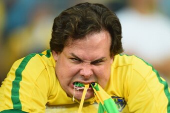 BELO HORIZONTE, BRAZIL - JULY 08: An emotional Brazil fan reacts after being defeated by Germany 7-1 during the 2014 FIFA World Cup Brazil Semi Final match between Brazil and Germany at Estadio Mineirao on July 8, 2014 in Belo Horizonte, Brazil.  (Photo b
