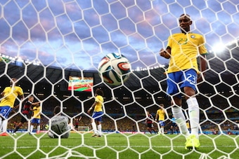BELO HORIZONTE, BRAZIL - JULY 08: Maicon of Brazil retrieves the ball from the net after Germany's second goal by Miroslav Klose (not pictured) past goalkeeper Julio Cesar during the 2014 FIFA World Cup Brazil Semi Final match between Brazil and Germany a